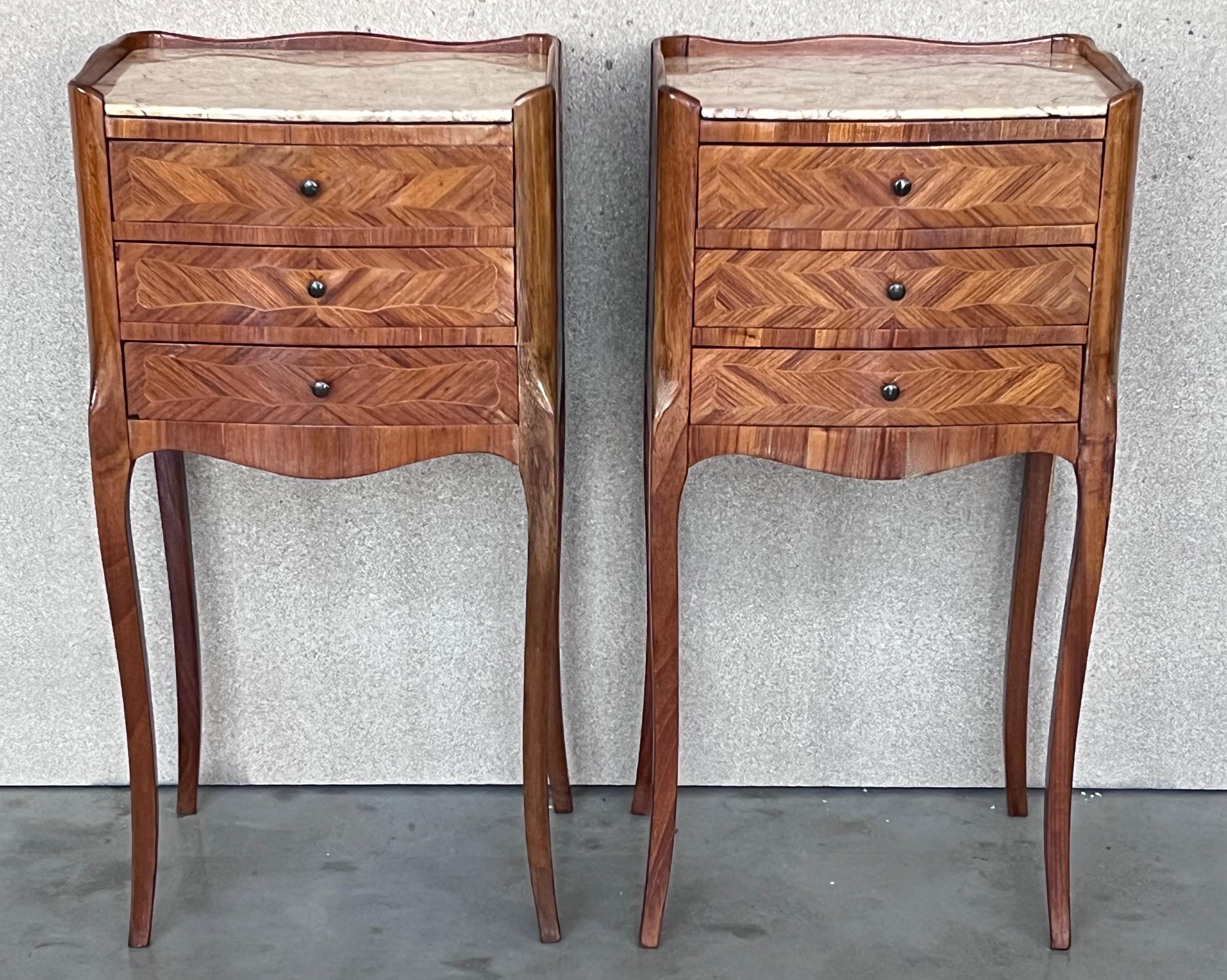 Antique French Louis XVI style pair of nightstands topped with a white marble, cabriole legs. Three dovetailed small drawers with brass details in pulls each table.