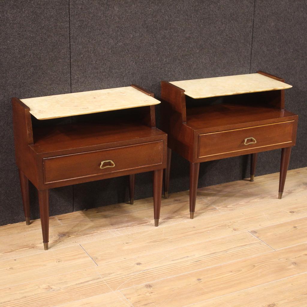 Pair of Italian bedside tables from the 70s/80s. Italian design furniture, of particular line and good taste, veneered in exotic wood, walnut, mahogany with interiors in light wood. Bedside tables equipped with a large capacity drawer, onyx top in