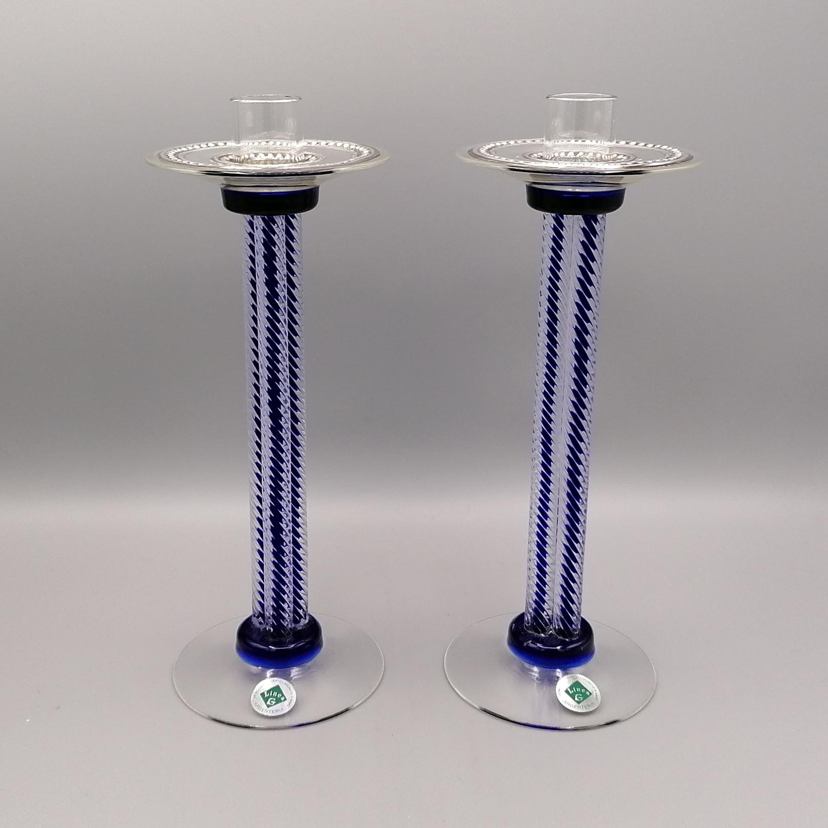 Pair of Murano glass candlesticks, Venice.
The glass is two-tone, transparent and dark blue.
The base is round and smooth with blue shades, while the stem is composed of three tall twisted columns with the dfark blue color inside.
The candle