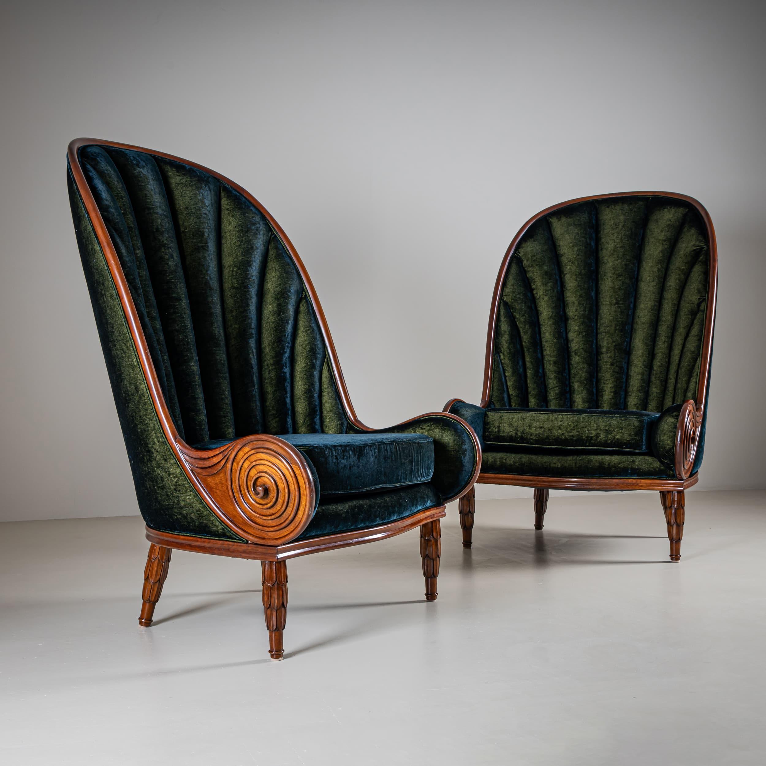 A pair of Nautilus model armchairs featuring high, elegantly curved backrests and spiral-shaped scroll arms. The upholstered backrests have a wave-like design evocative of a seashell. The frame is crafted from shellac-polished walnut. Seats and