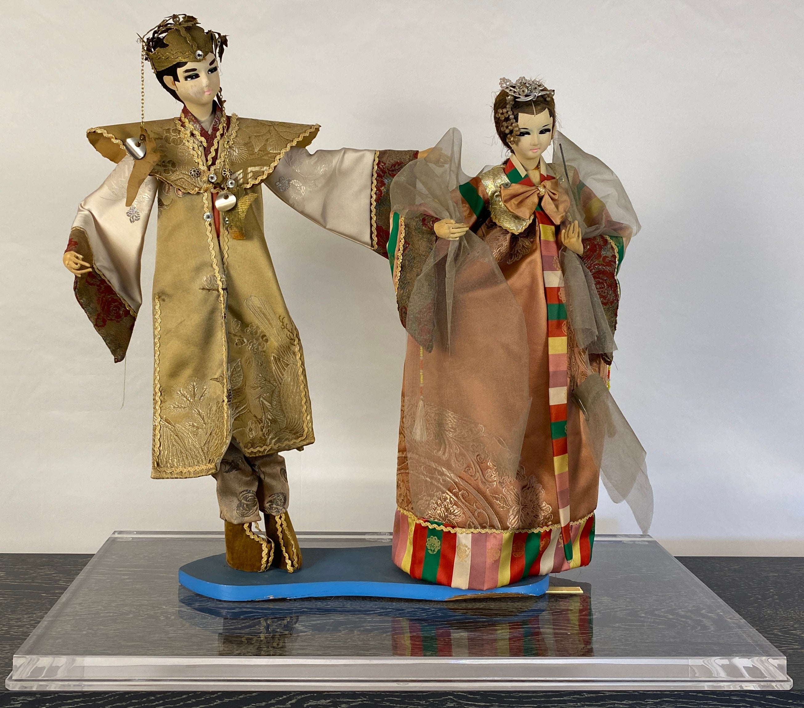 A fine quality pair of 20th century Oriental puppet dolls with original costumes.

These decorative Oriental puppets are framed in Lucite making them easy to display on a table, console or shelf. Interesting and pleasing to the eye. Delivered