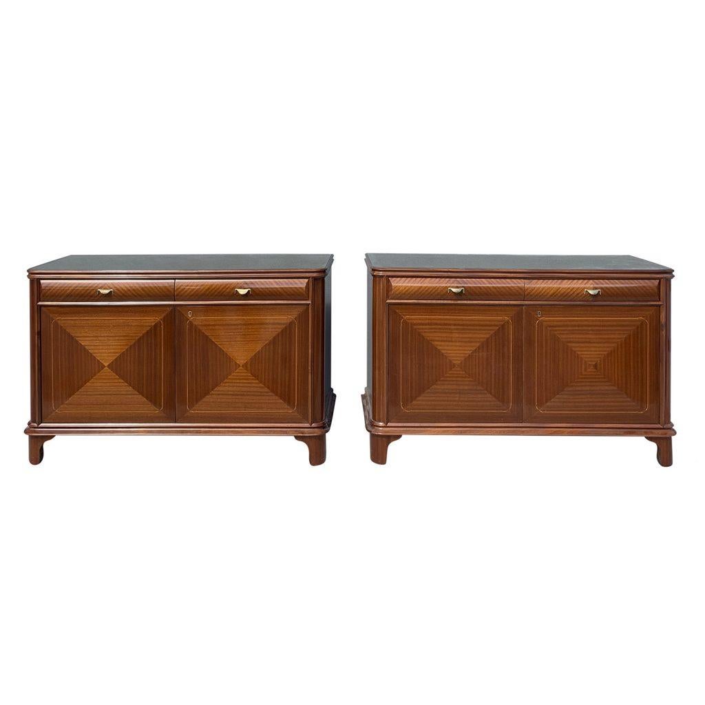 A light-brown, vintage Mid-Century modern Italian pair of sideboards made of hand crafted polished Walnut with original hardware. The commodes have a glass top with two drawers and two doors each, enhanced by brass handles. Designed by Paolo Buffa
