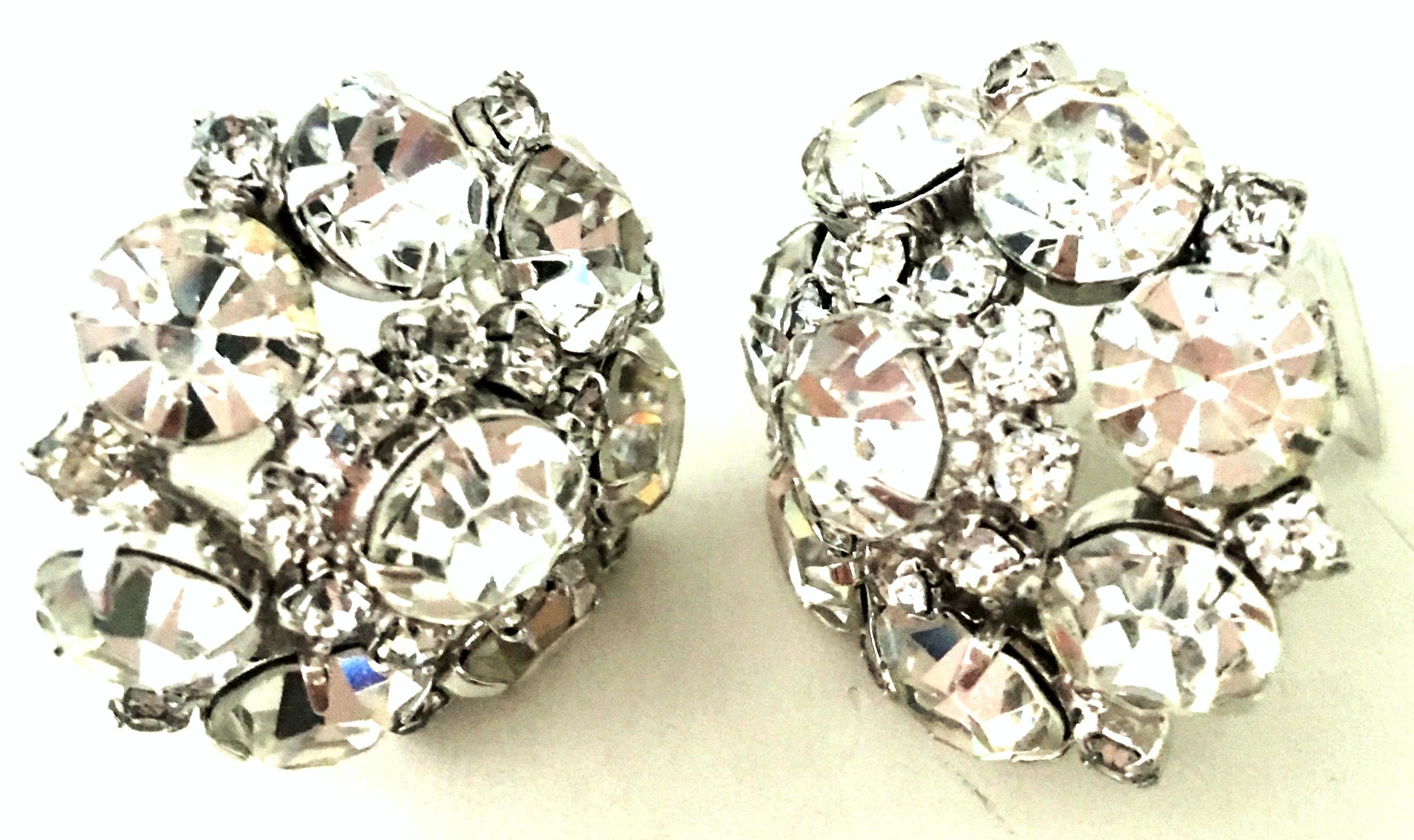 20th Century Pair Of Silver & Austrian Crystal Earrings By Weiss. These silver rhodium plate earrings feature brilliant cut and faceted colorless Austrian crystal fancy prong set stones with an abstract floral motif.
