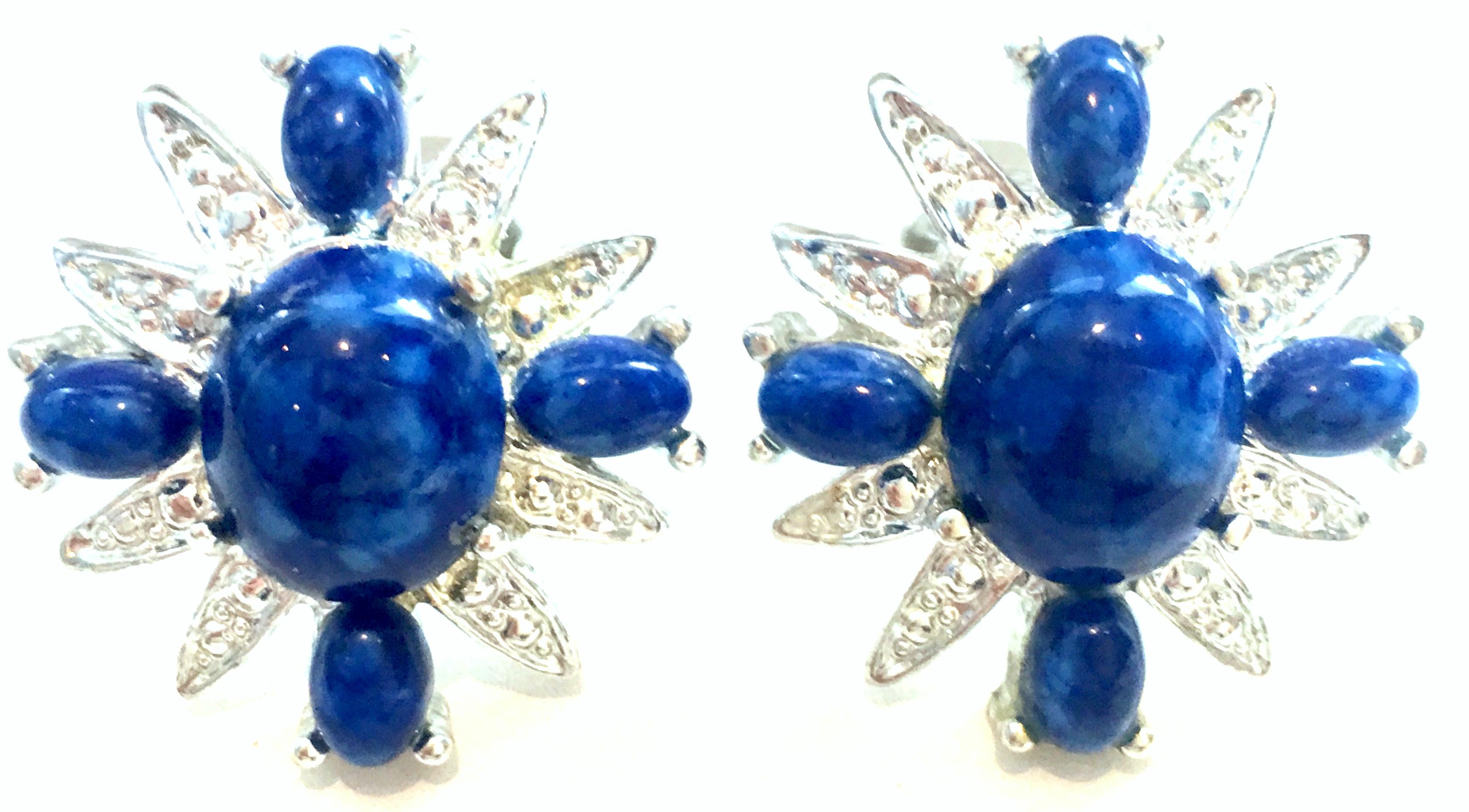 20th Century Pair Of Silver Plate & Faux Lapis Lazuli Earrings By, Sarah Coventry. These silver plate and faux Lapis Lazuli clip style dimensional earrings feature an abstract Maltese cross design. Each piece is signed on the underside, Sarah.