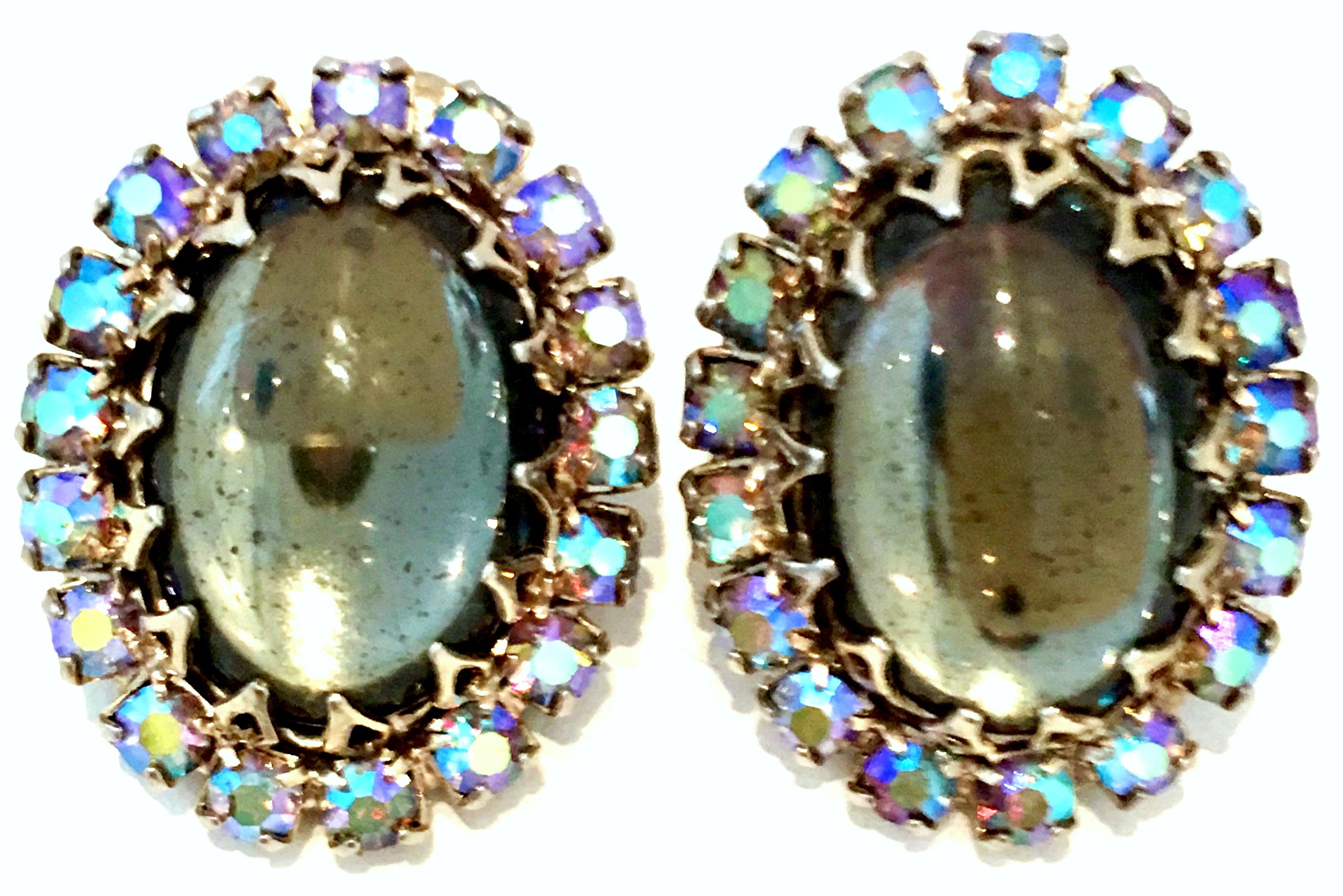 Mid-20th Century Sterling Silver, Art Glass & Austrian Crystal Earrings. These unique clip style earrings feature a large central dome shape art glass moonstone surrounded by Aurora Borealis Austrian fancy prong set crystal.
