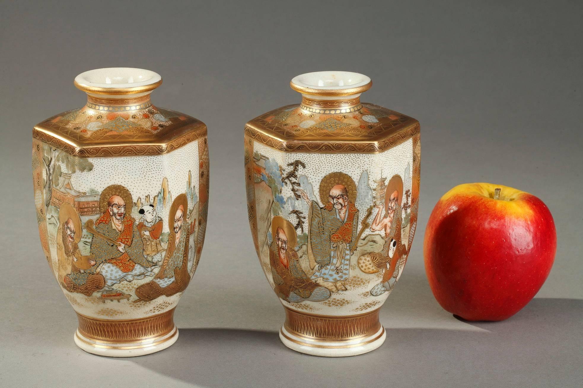 Zwei sechseckige Satsuma-Vasen aus Porzellan, polychrom emailliert und vergoldet. Der Bauch ist mit verschlungenen japanischen Schriftzeichen in einer Landschaft verziert, der Hals und die Schulter mit geometrischen Mustern. Jede Vase trägt die