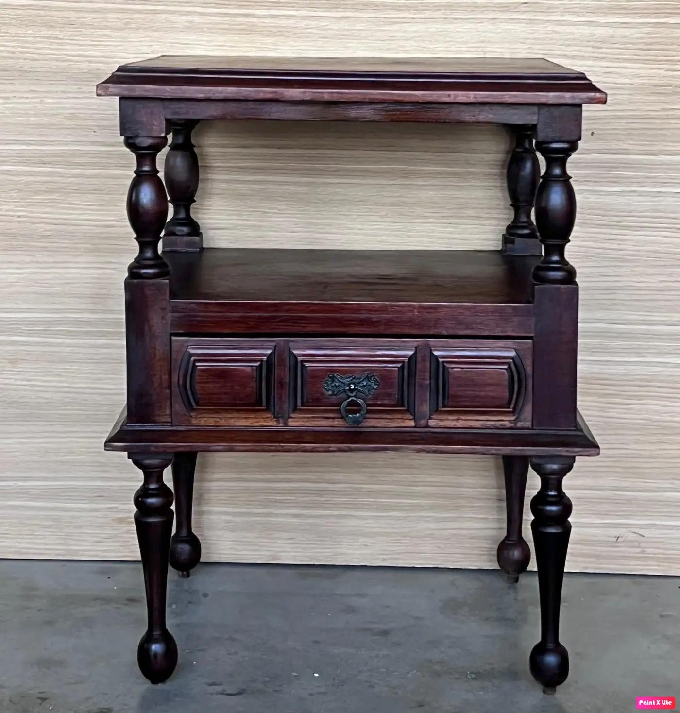 XX secolo Coppia di comodini spagnoli in legno massiccio intagliato con un cassetto basso intagliato con tiretto originale in bronzo.
