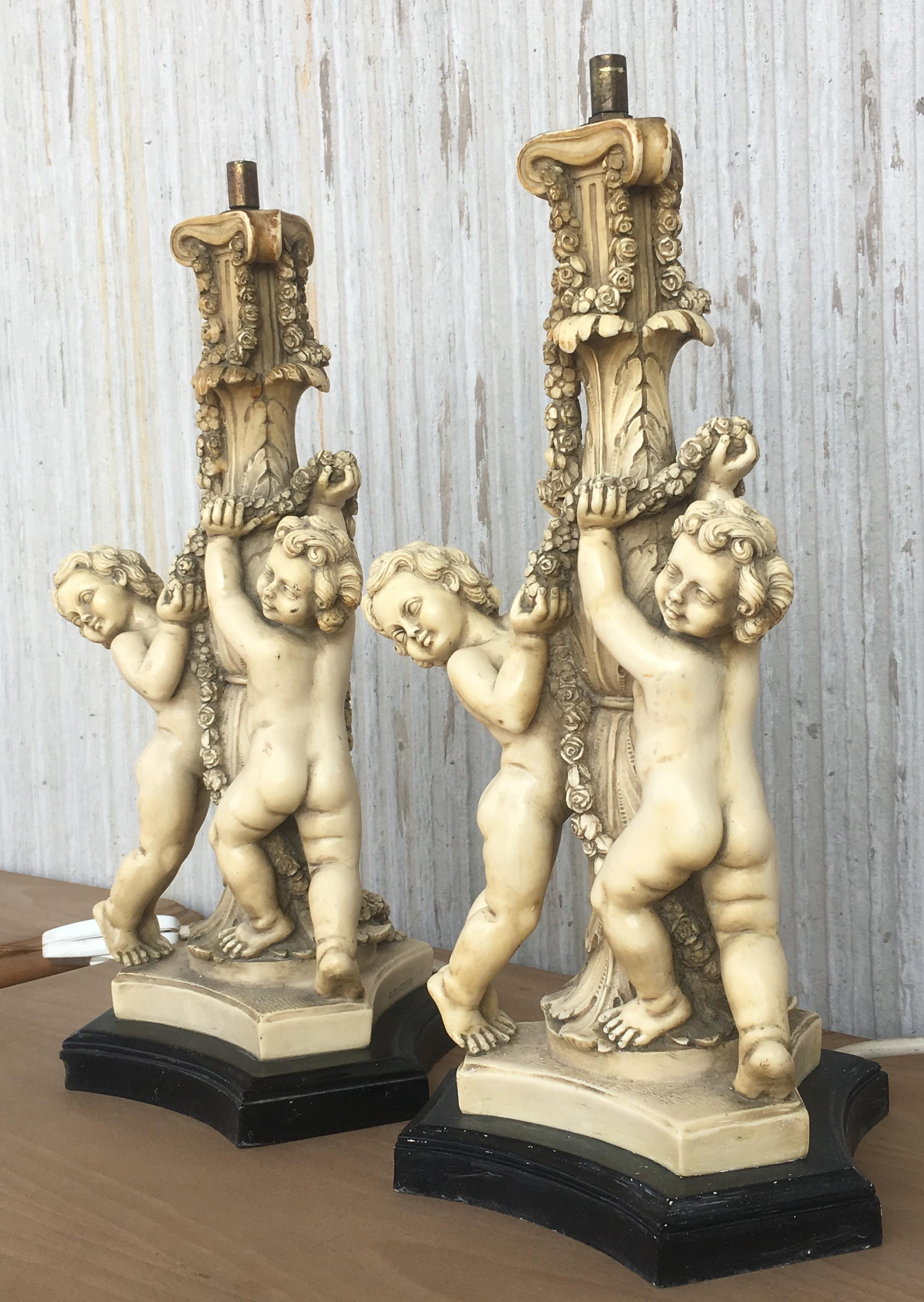 These lamps have a white creram glazed finish that covers this pair of resin cherubs from Italy in the early 20th century. They sit upon black finish wooden bases.
By sculptor G. Ruggeri, Italy

Gino Ruggeri was from Italy - G. Ruggeri, is one of