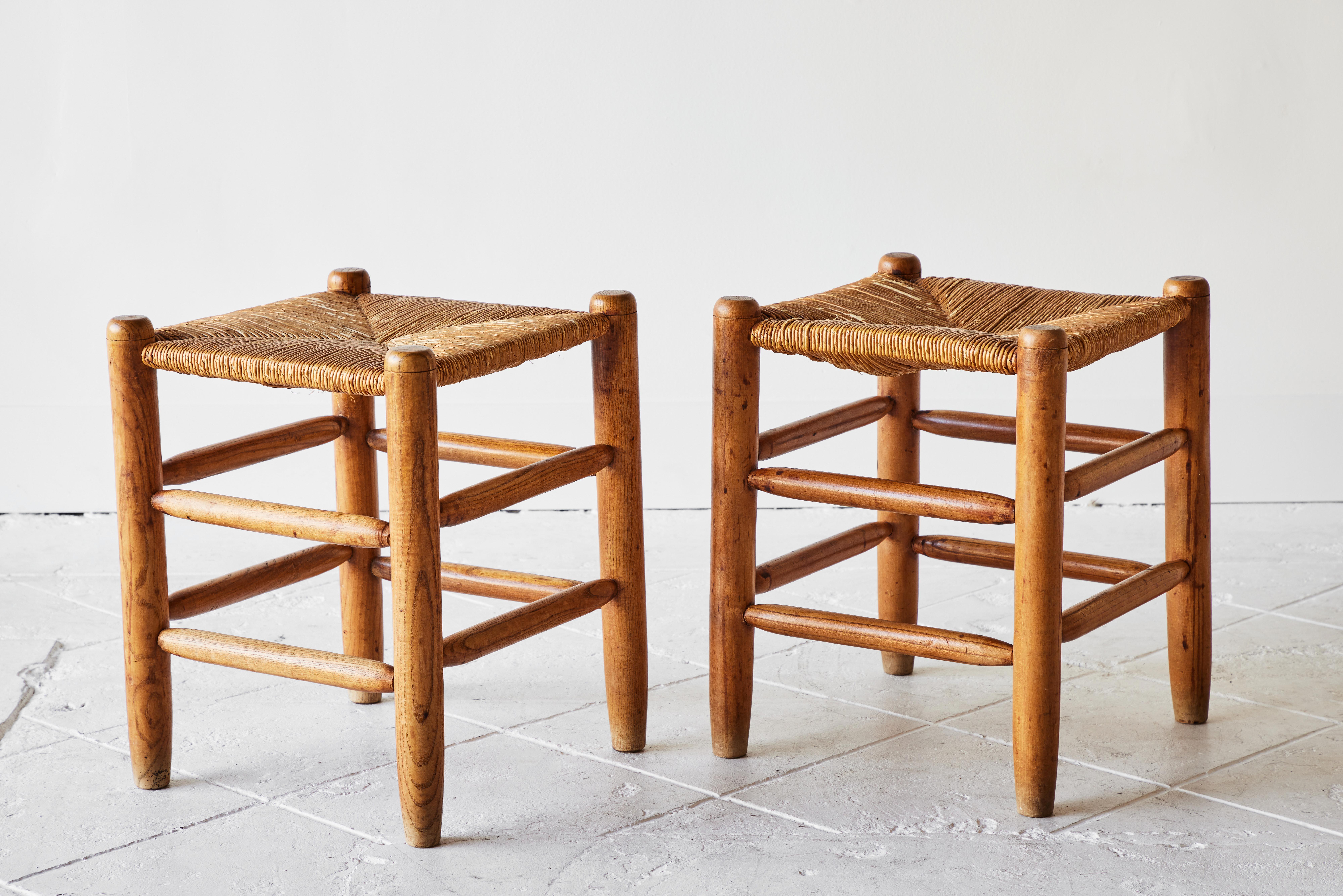 These farmhouse or Provincial style stools are in perfect condition and feature original rush seats and a beautiful patina. The pair of handcrafted early to mid-20th century stools are the ideal organic styled touch to any room.
