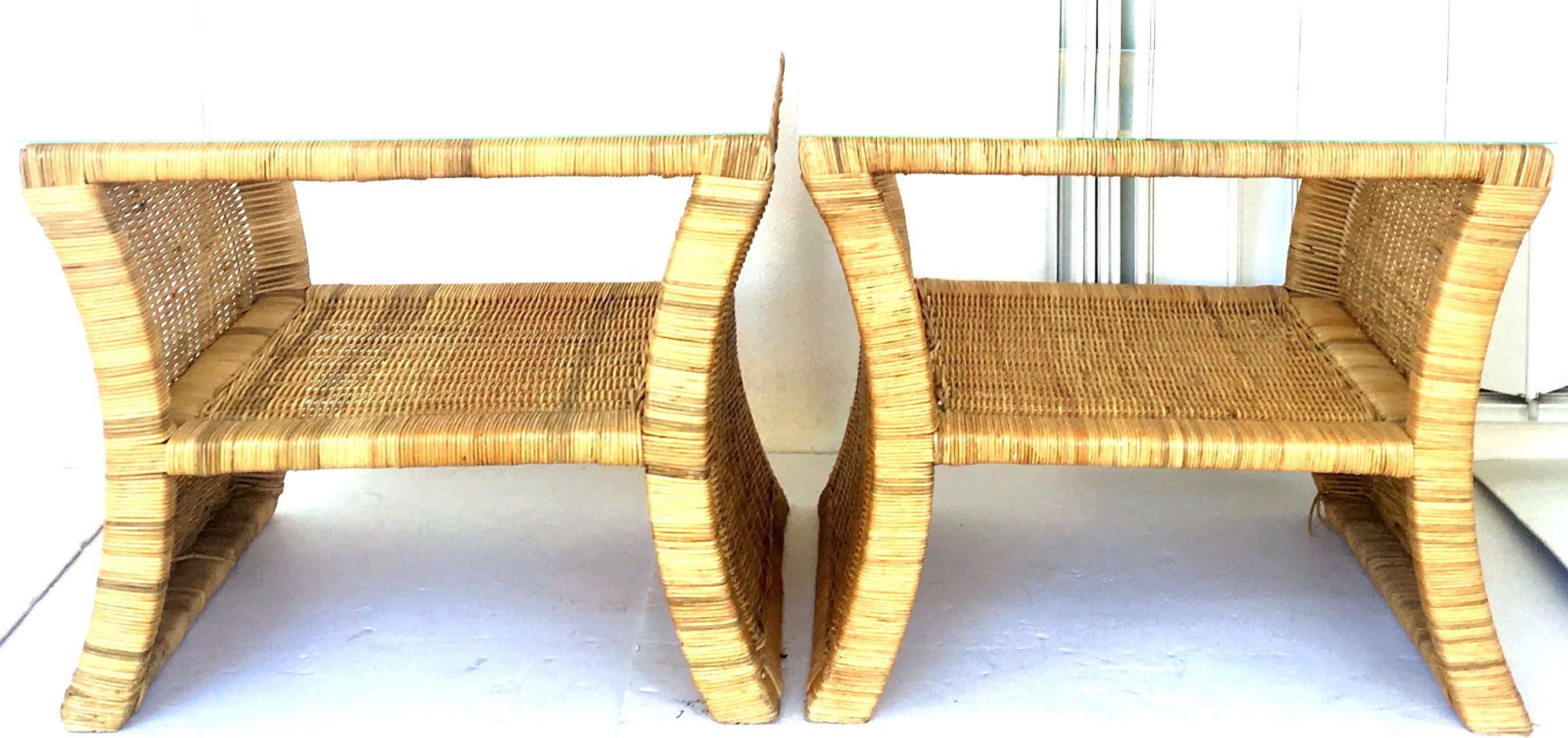 20th Century pair of woven rattan wicker bent and wrapped slanted side glass top side or end tables. These rare and unique tables with slanted sides feature a single open storage shelf and new glass tops that are not attached.
Glass tops have been