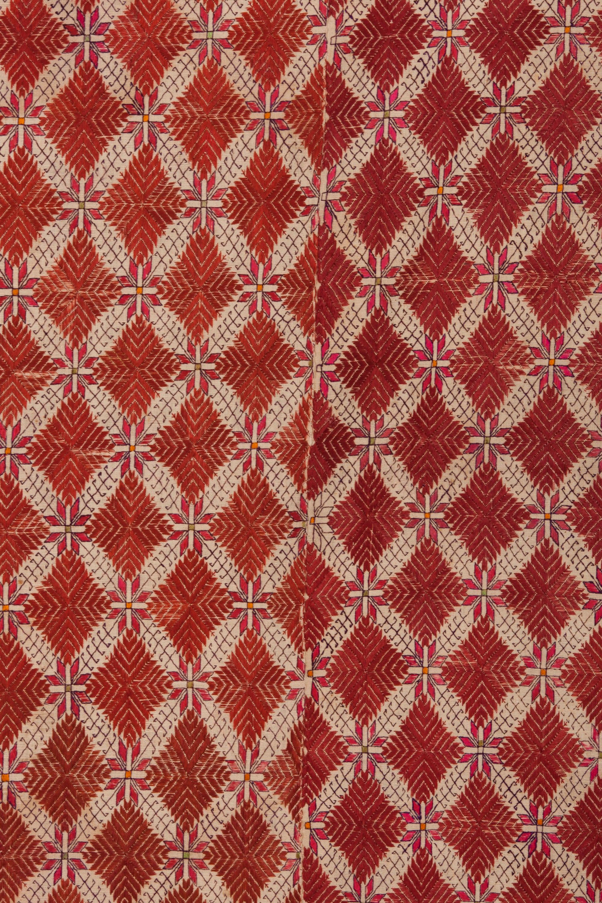 This elaborately embroidered Pakistani wallhanging was made using silk thread. Phulkari embroidery on handspun woven cotton (called khaddar). The piece is constructed in 3 sections joined on selvedges; left and right edges bound by embroidery. A