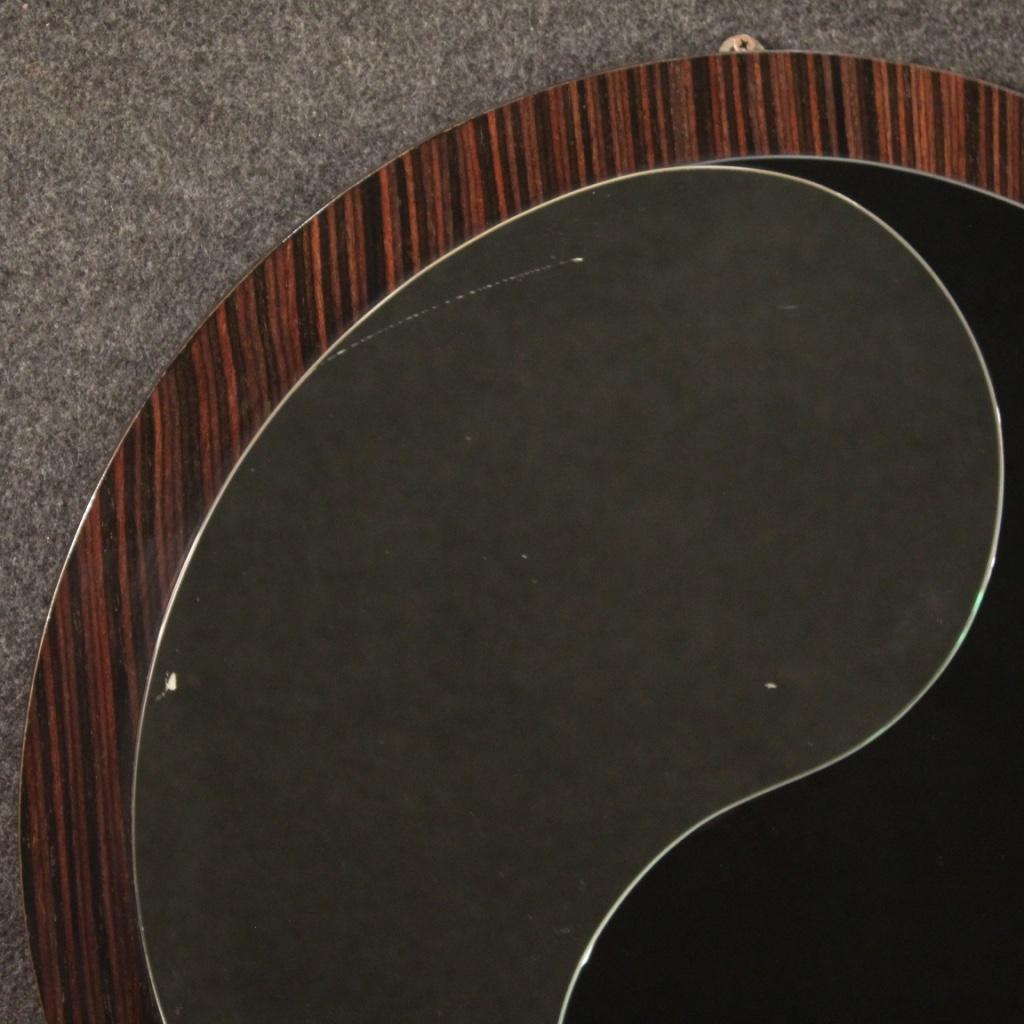 Italienischer Designspiegel aus den 1970er-1980er Jahren. Palisanderfurnierte Möbel mit zwei Yin- und Yang-Spiegeln verziert. Spiegel (von denen einer undurchsichtig ist) mit kleinen Flecken (siehe Foto) ohne Bruch oder Absplitterung. Kleine Größe
