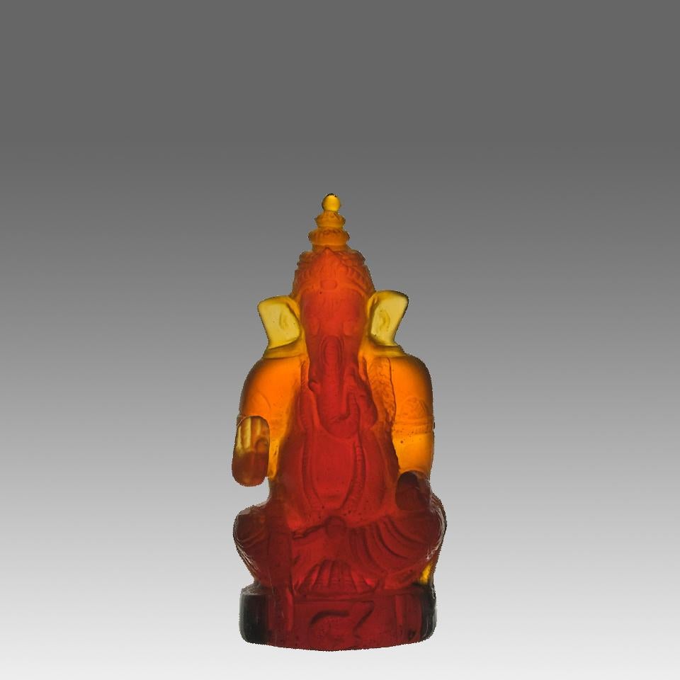 A wonderful mid 20th Century pate-de-verre golden amber glass study of a Ganesh inspired figurine of a seated elephant exhibiting excellent vibrant colour, signed Daum France

Ganesha (also Ganesa or Ganapati) is one of the most important gods in