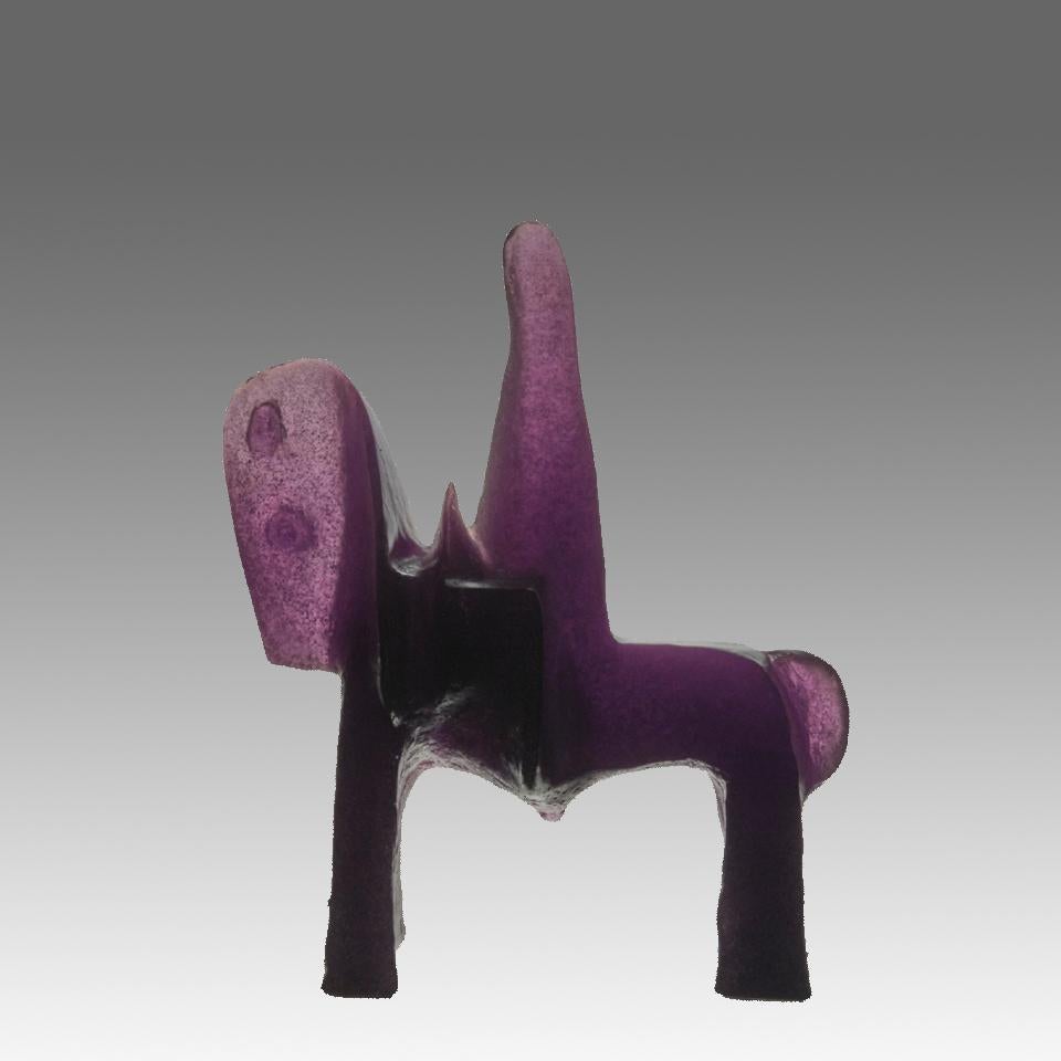 Un'impressionante scultura in vetro pâte-de-verre della metà del XX secolo che raffigura un cavallo e un cavaliere astratti, realizzati con ricchi toni viola traslucidi. Il pezzo presenta dettagli raffinati e una composizione dinamica e modernista.