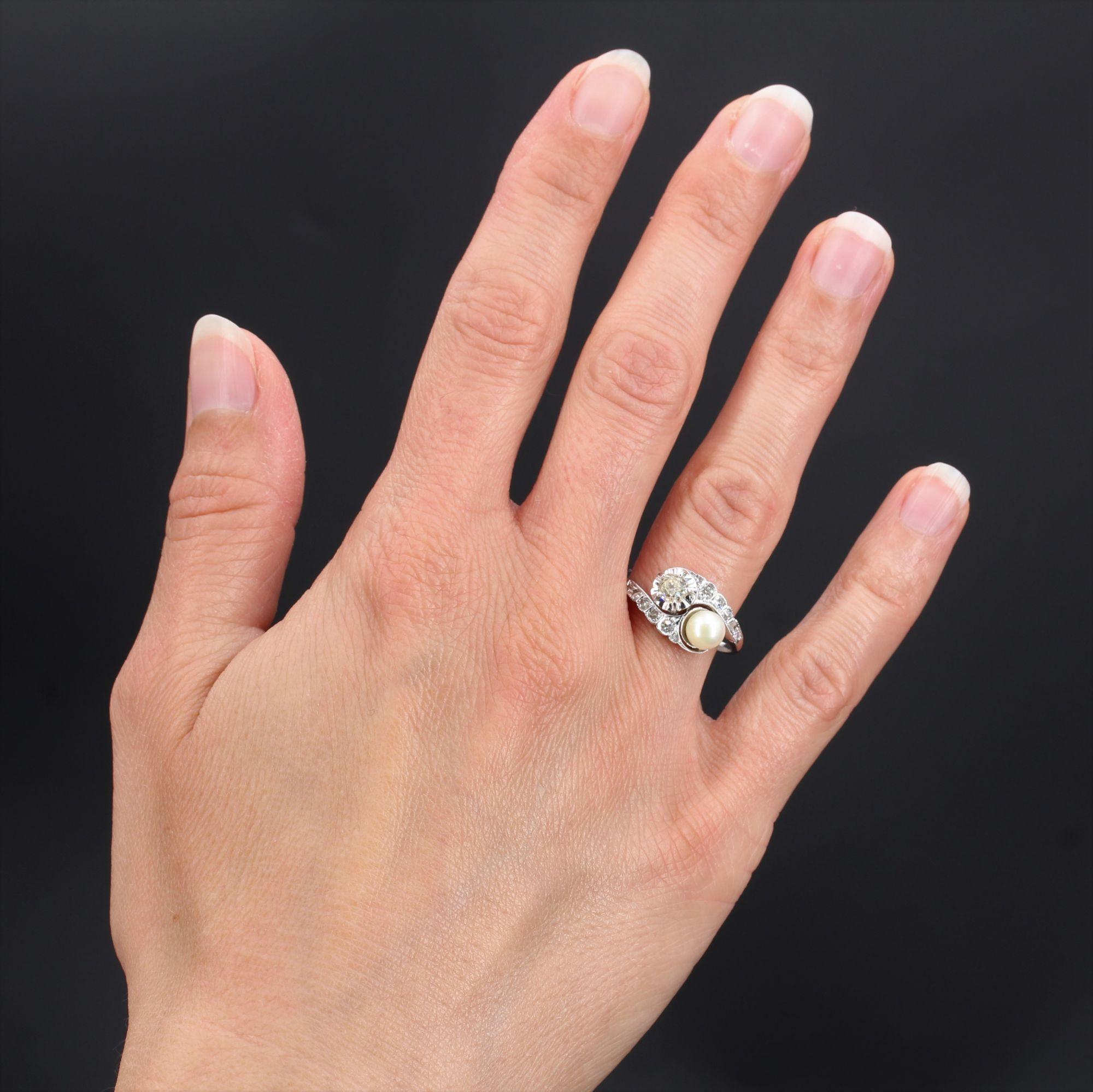 Ring in 18 karat white gold, owl hallmark.
Charming antique you and me jewel, this ring is set on its top of an antique cushion-cut diamond in illusion setting, and a cultured pearl of white orient. On both sides, the setting is decorated with a