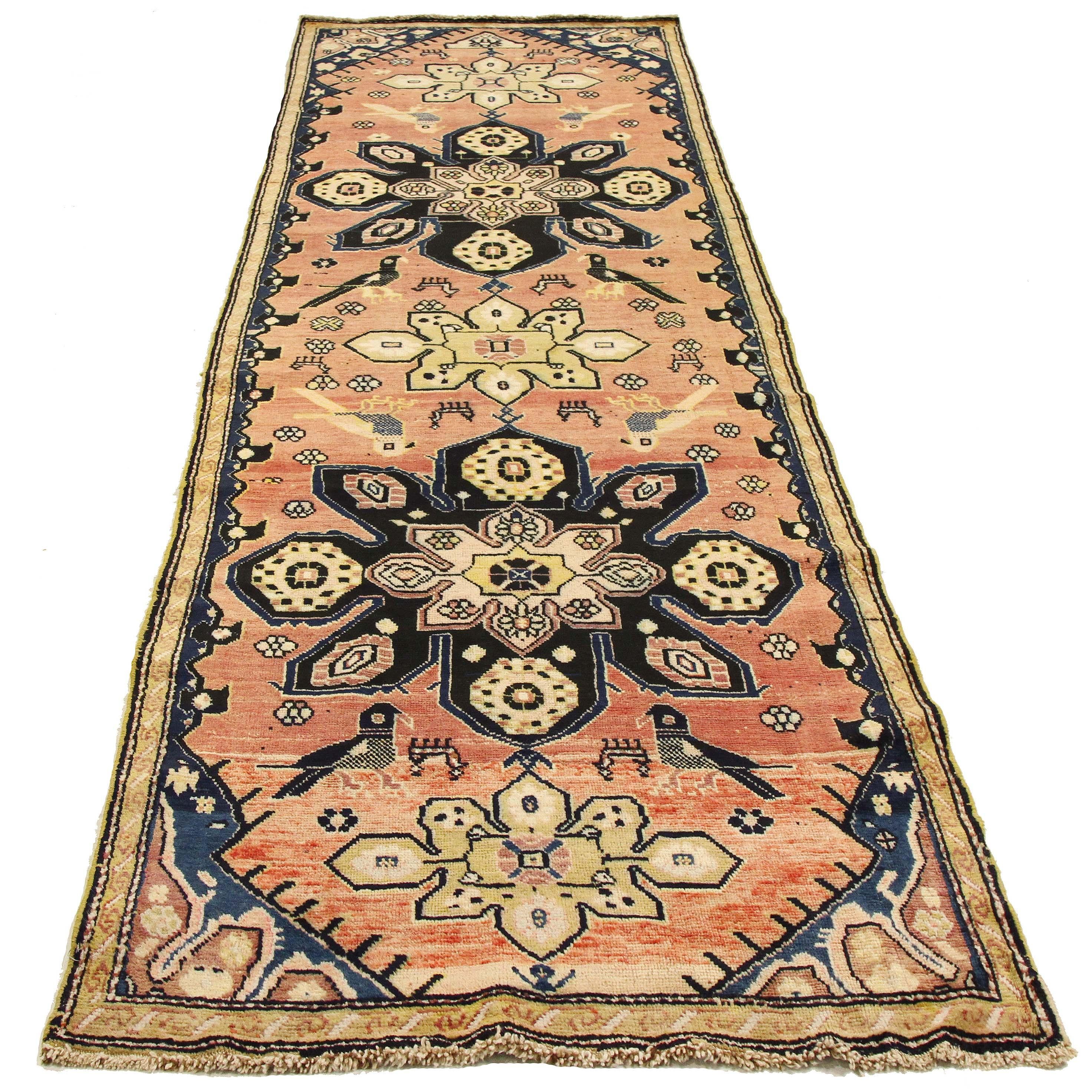 Antique Persian runner rug from the 20th century handwoven from the finest sheep’s wool and colored with all-natural vegetable dyes that are safe for humans and pets. It’s a traditional Karabagh design featuring a blend of colorful flowers and bird