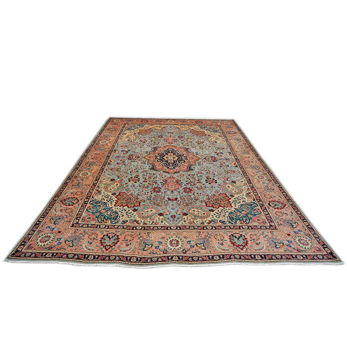 A fine woven 1940s Persian Tabriz with a light blue field populated with fine detailed medallion floral designs.
Accent colors include green, taupe, salmon, and light blue.
The rug is bounded by a navy blue and light salmon floral border.