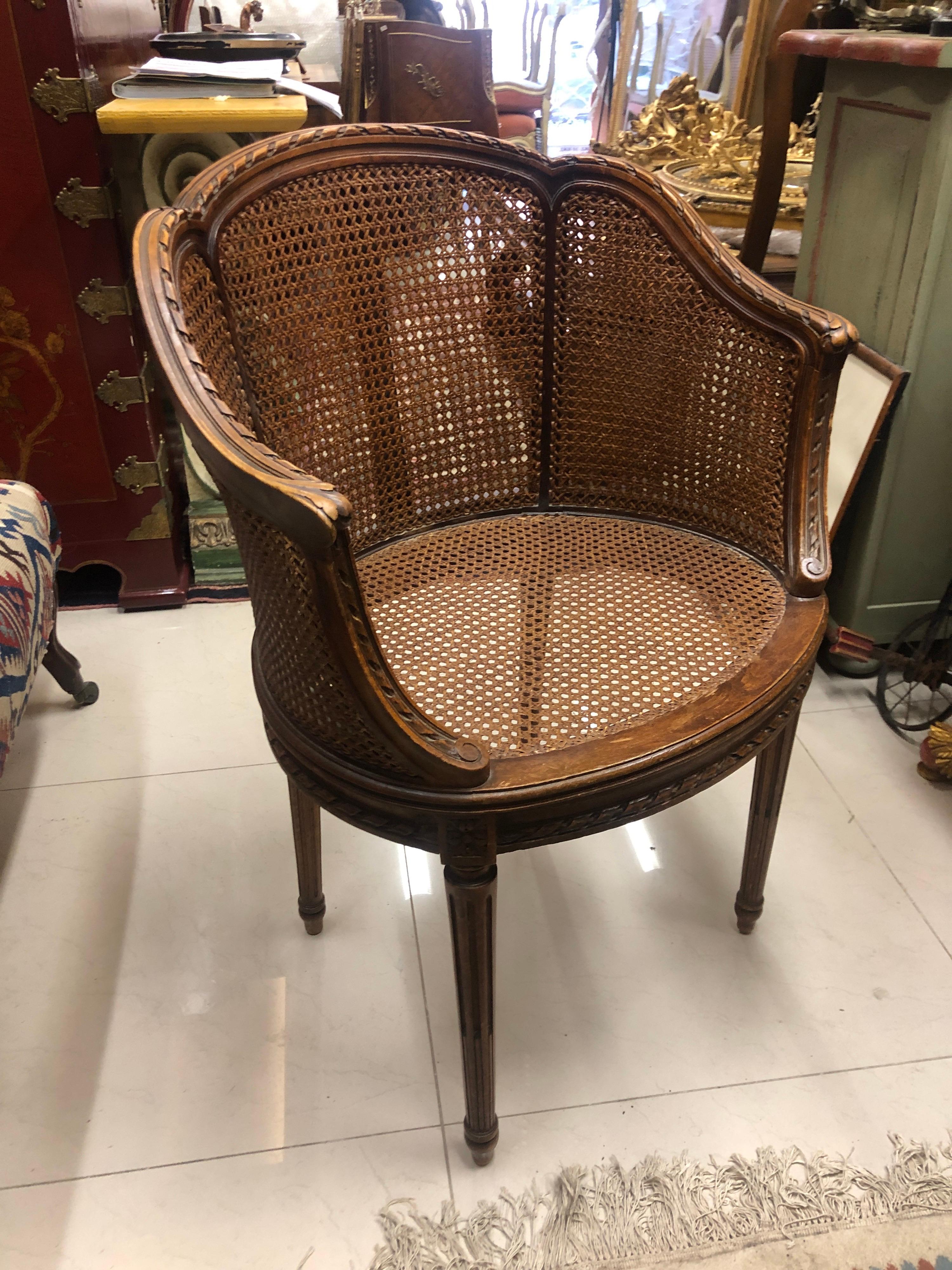 Petite French round armchair, in Louis XVI style hand carved and decorated with friezes of ribbons tapered fluted base, with dobble cane back and the seat. Very good condition. Still wearing the original label under the seat 
