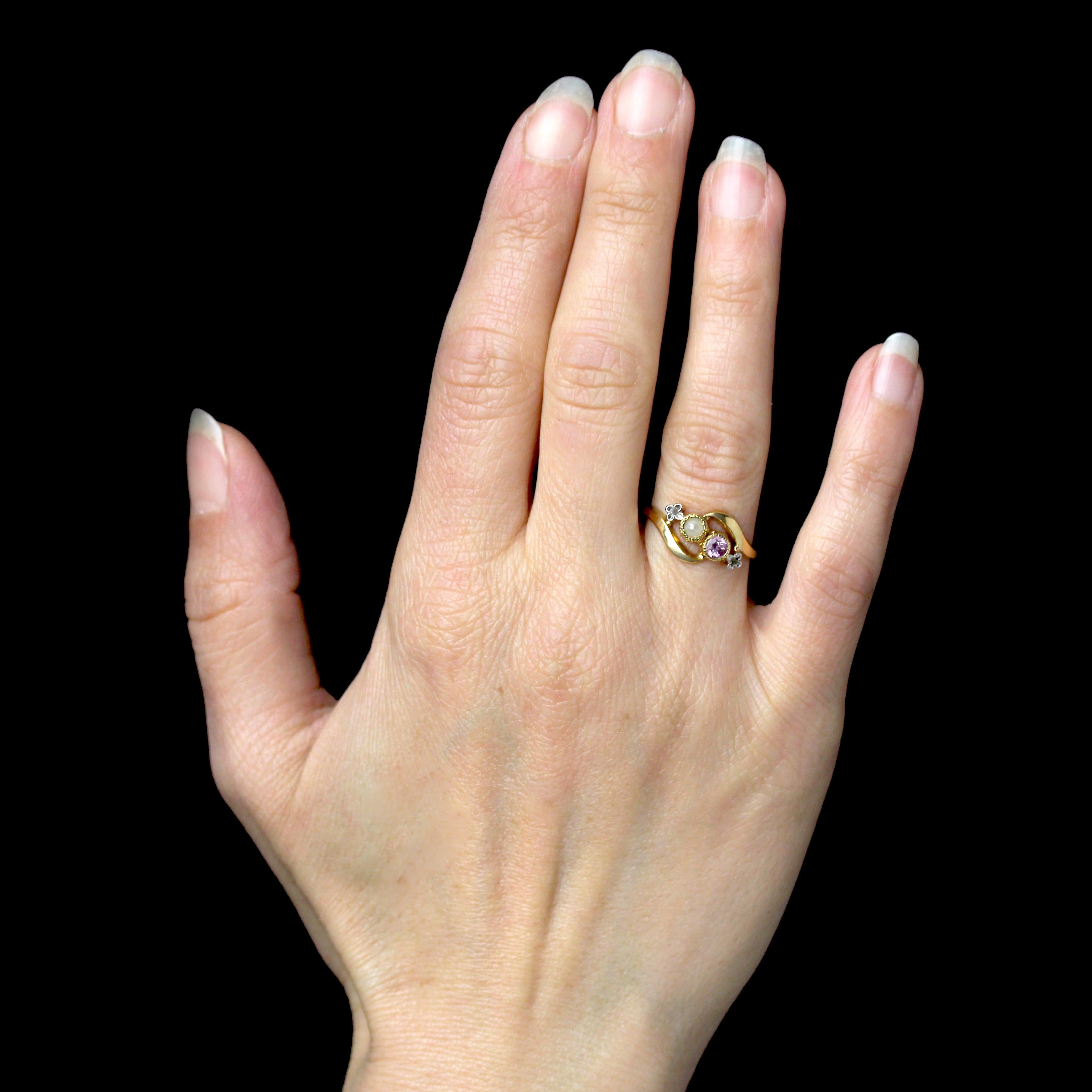 Bague en or jaune 18 carats, poinçon tête d'aigle.
Elégante bague ancienne de la Belle Epoque, avec un mouvement au sommet et un serti clos perlé d'une fine demi-perle et d'un saphir rose. Deux diamants taillés en rose, sertis sur des motifs de