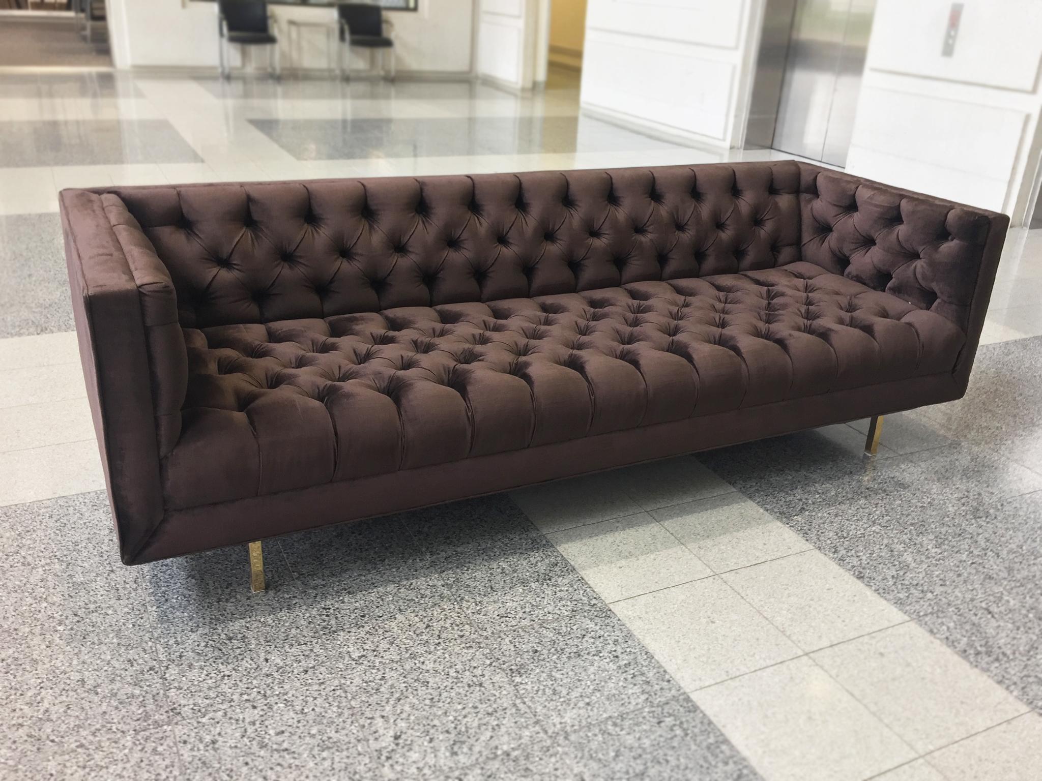 An elegant vintage Chesterfield sofa in the chic modern style of Milo Baughman. The sofa is upholstered in a plum-hued velvet. Its interior seat, backrest, and arms are button-tufted, while its legs are a complementary gold chrome. This sofa's