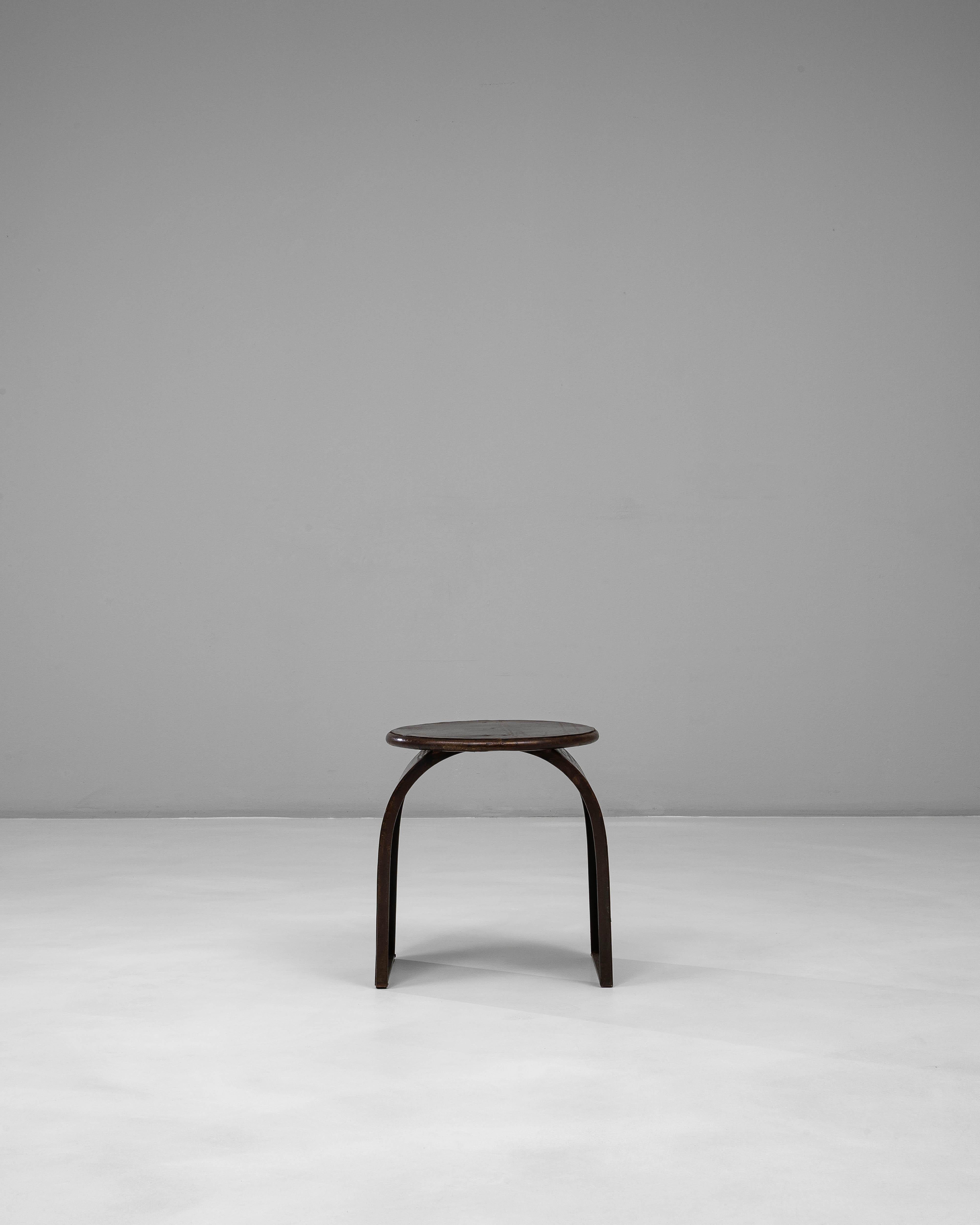 Dieser geschwungene polnische Metallhocker aus dem 20. Jahrhundert hat eine markante skulpturale Silhouette, die durch die gebogenen Beine und die runde Sitzfläche definiert wird. Das aus gebogenem Metall gefertigte Design zeichnet sich durch Stärke