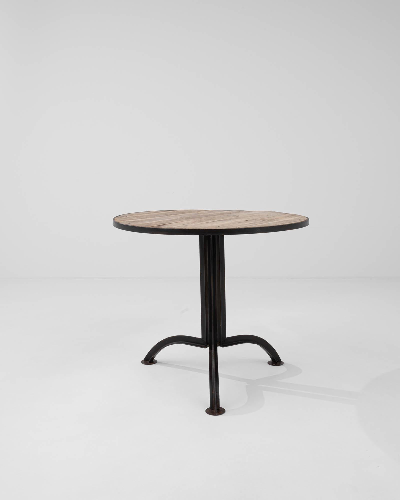 Boldly elevated on its modernist tripod metal base, this side table embodies the brutalist aesthetic that was popular in Eastern European furniture design at the beginning of the 20th century. The circular tabletop, crafted from bleached wood,