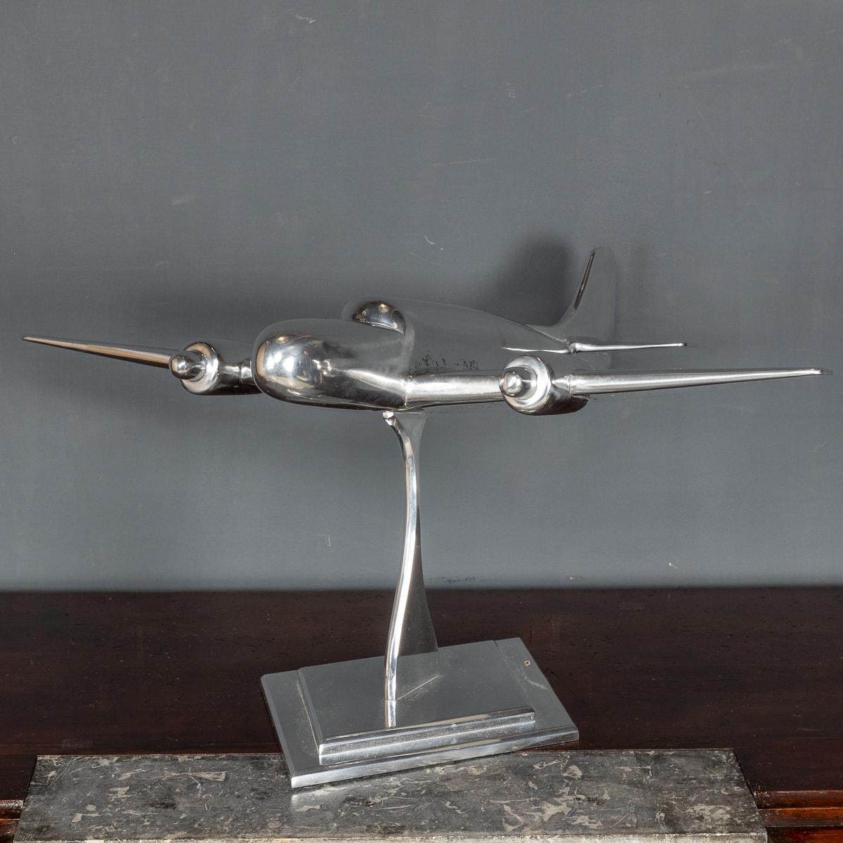A Stunning mid-20th century model of an bomber airplane, made of polished aluminum, standing on an elegant art deco style stand.

CONDITION
In Great condition - No damage, just general wear.

SIZE
Height: 39cm
Width: 77cm
Depth: 60cm