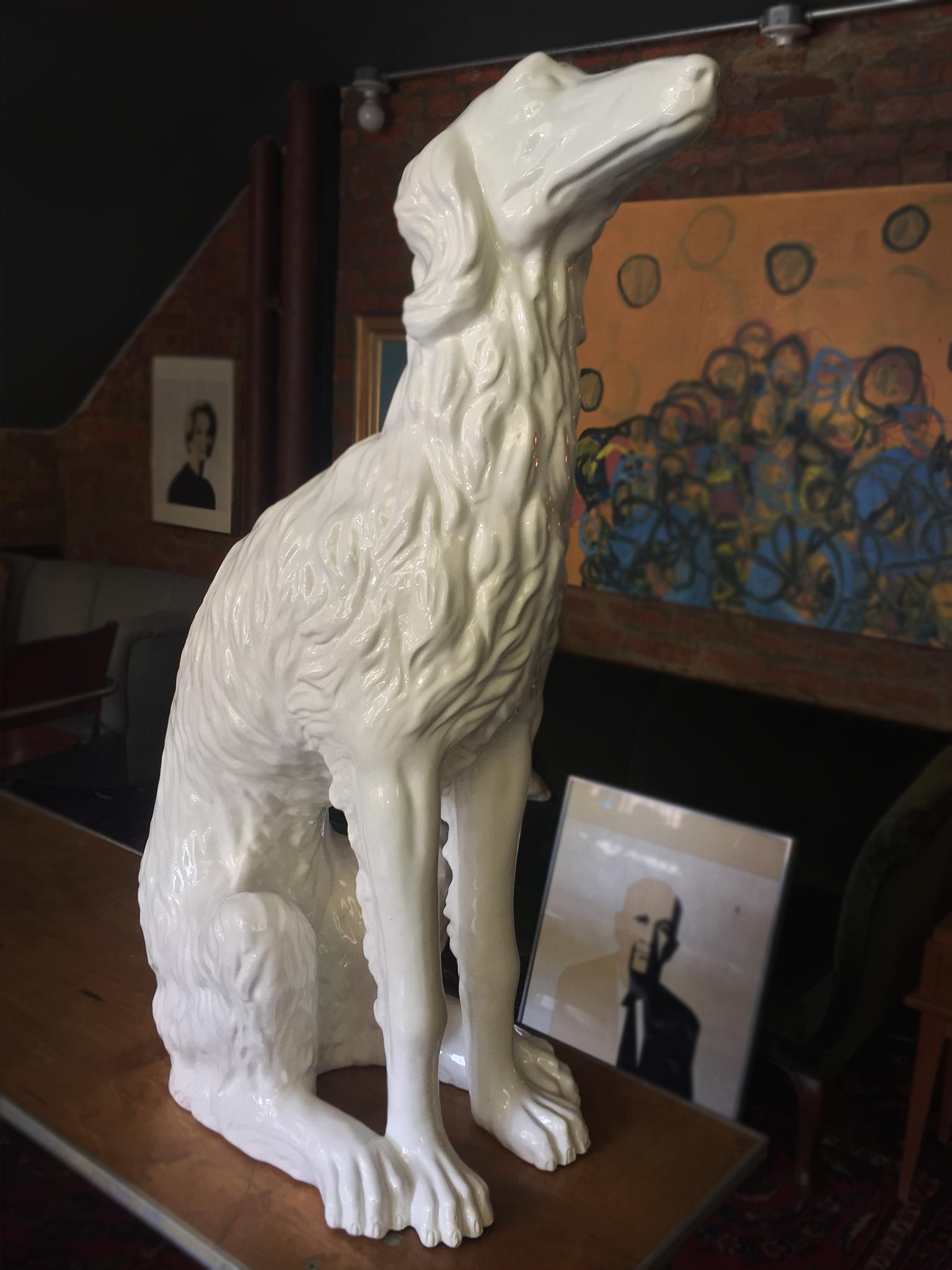 20th century bone-white porcelain figure of a Russian Wolfhound, also known as a Borzoi dog. It is crafted with attention to the textural details of fur. Not only is the sculpture life-size, it also radiates with the warm character we might expect