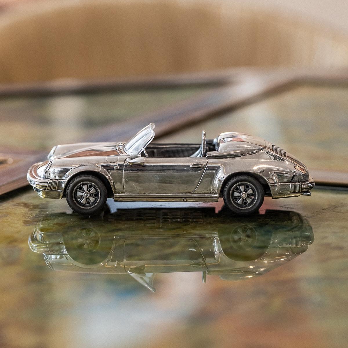 A mid 20th Century solid silver model of a Porsche 911 convertible sports car. This timeless model has wheels fitted with Bridgestone rubber tyres. The exterior is polished to a high shine and internally there is exceptional detail within the