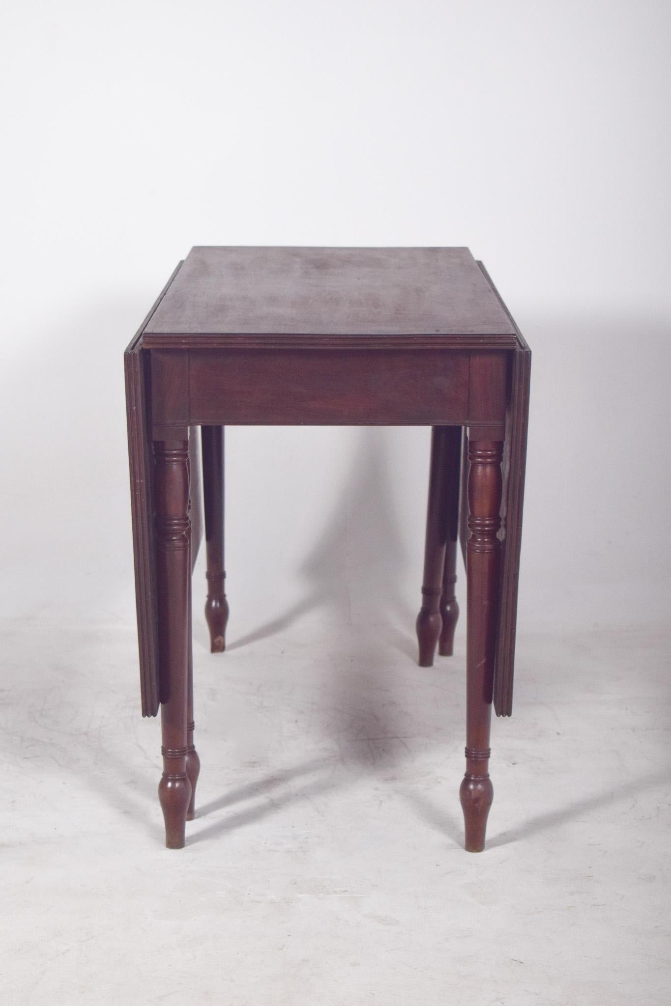 Square-top table. In dark wood, it has a polished finish, giving the piece a sober and timeless look.
The top is made up of three parts, a fixed central part and two rectangular side flaps, which can be raised to extend the usable surface. When