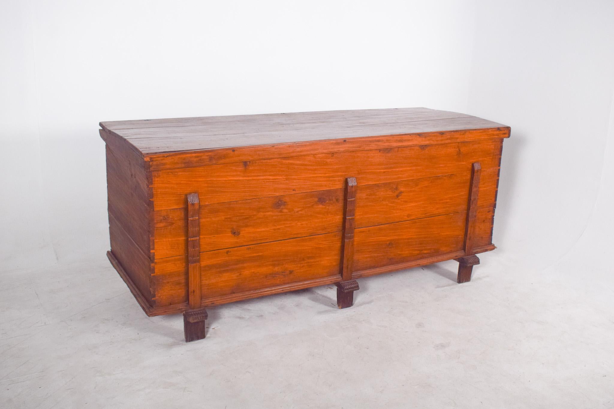 Arcón grande de madera de concha. Tiene tres travesaños verticales aplicados en la parte delantera, con tallas decorativas y pies ligeramente elevados en forma de zapato. De construcción robusta y proporciones generosas, este mueble revela un