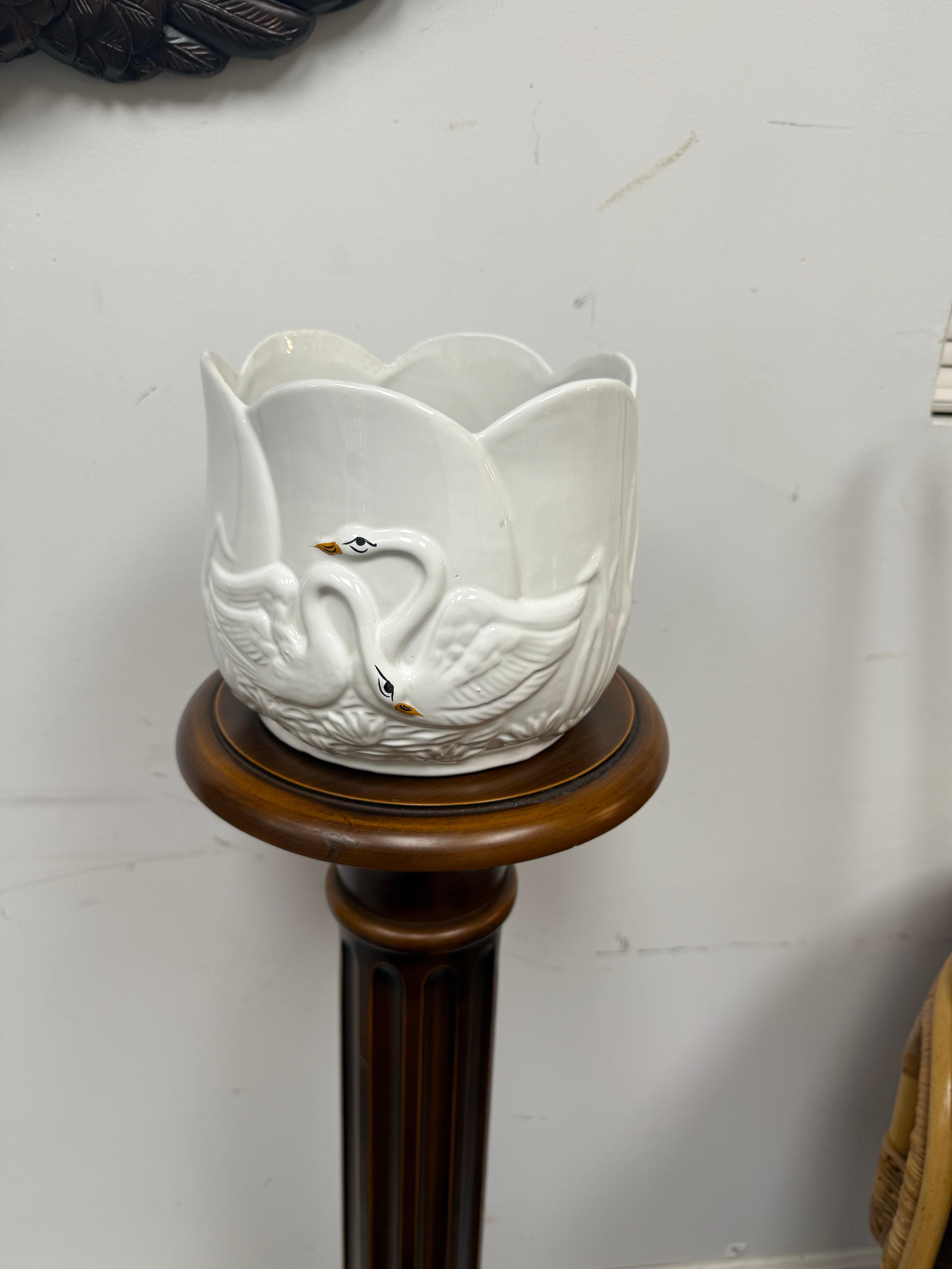 Esta bonita maceta con forma de cisne pintada a mano tiene un aire asiático, con flores de loto en relieve cerca de la base.   2 cisnes a cada lado. La maceta tiene forma de loto.  Firmado en la parte inferior y 
