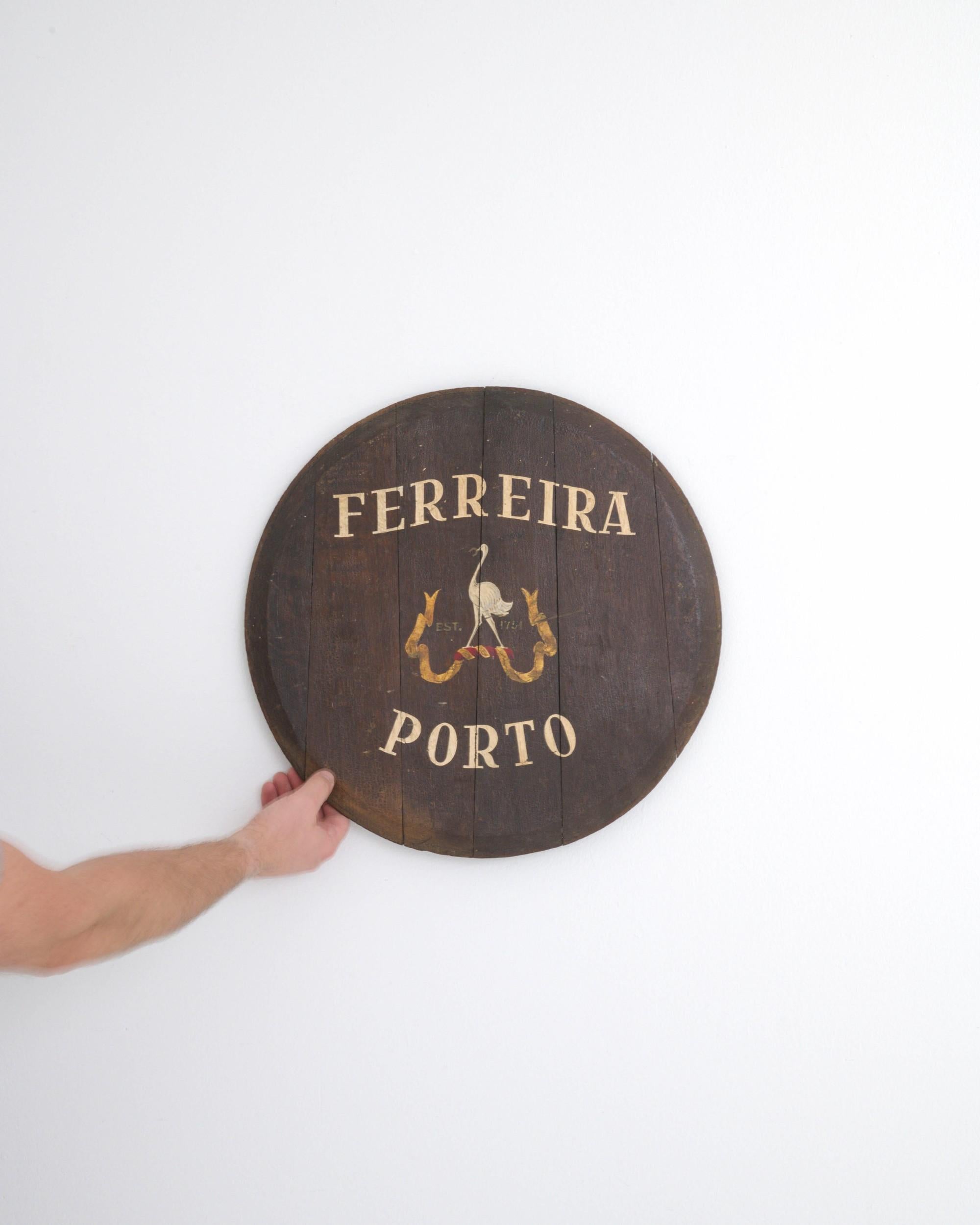 Diese authentische Wanddekoration aus Holz, ein Fassdeckel, stammt aus dem 20. Jahrhundert und ist eine Vintage-Rarität aus Portugal. Es zeigt einen gemalten Reiher mit einem Hufeisen im Schnabel auf einem gelb-roten Band, das die Jahreszahl 1751