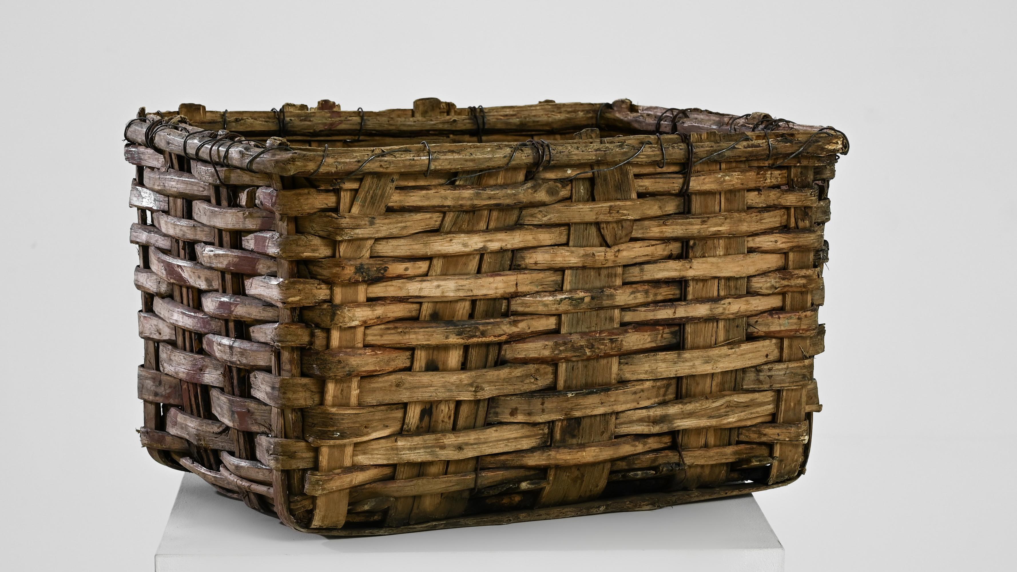 This handmade grape basket from 20th century Portugal makes a beautiful rustic accent. Textural and romantic, thick strips of wood are expertly woven to form a deep rectangular container. Originally used in the luminous vineyards of the