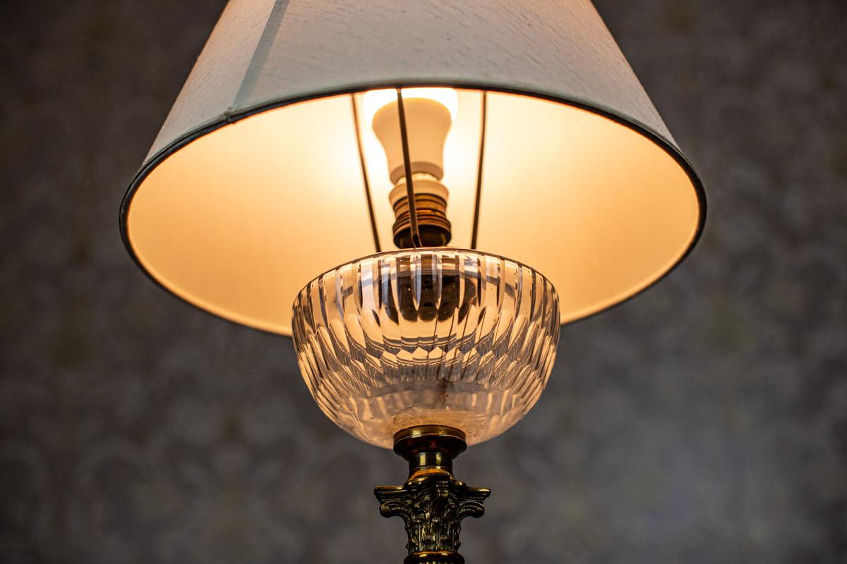 Lampe de table d'avant-guerre du 20e siècle avec abat-jour léger

Nous vous présentons une lampe électrique fabriquée à partir d'une ancienne lampe à pétrole.
La base a la forme d'une colonne supportant un bénitier en verre.
Il y a une douille pour