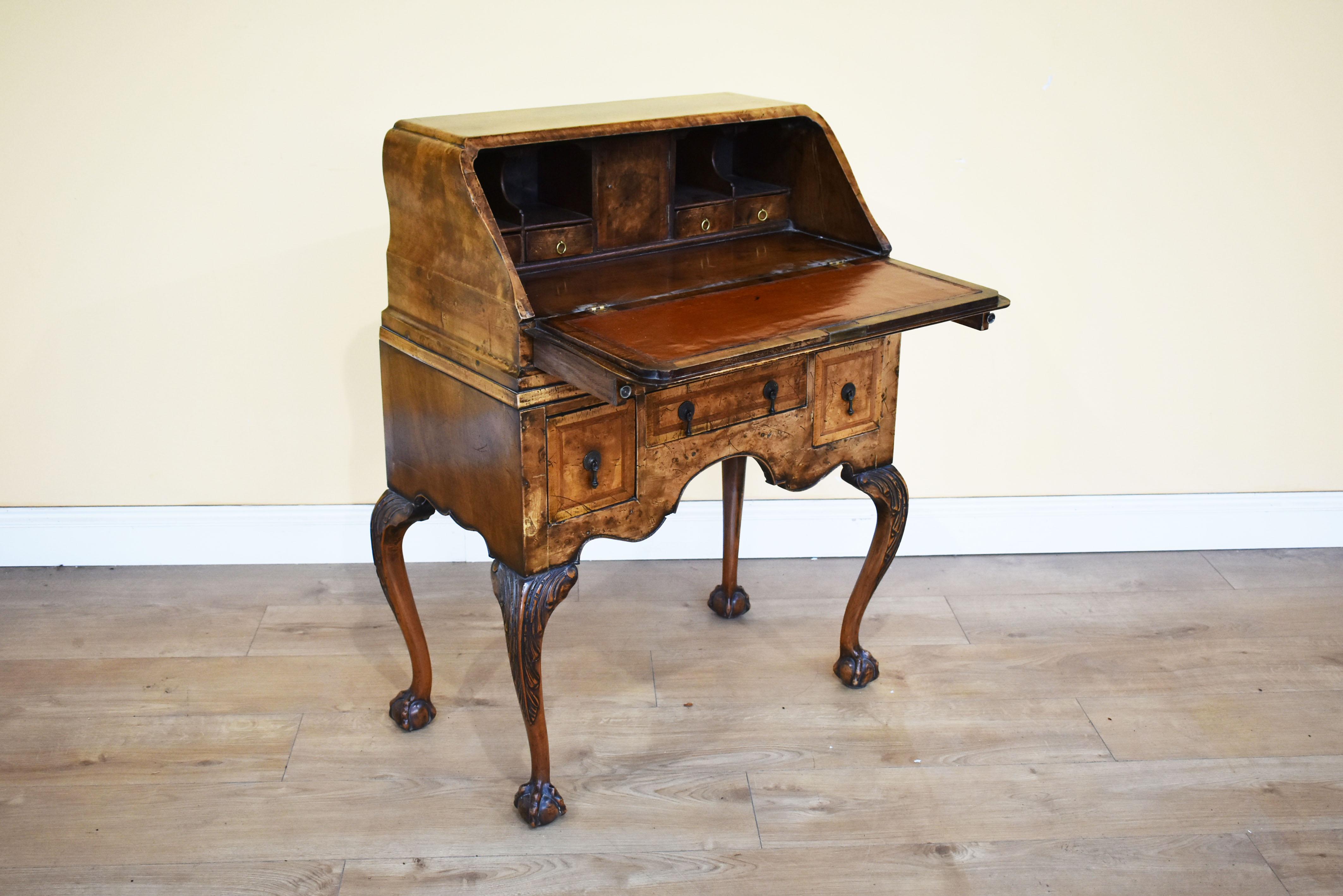 For sale is a good quality 20th century Queen Anne Revival burr walnut bureau, the shaped fall having a brass escutcheon and herringbone inlay, opening to reveal a fully fitted interior consisting of four drawers, each with brass ring handles,