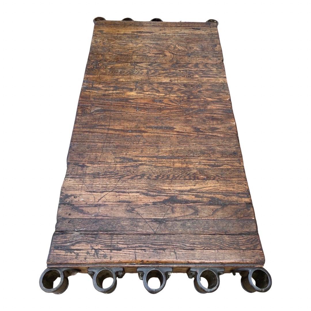 Gorgeous industrial railroad cart coffee table made in the United States in the early 1900s using oak and cast iron. This coffee table was originally made to transport lumber and tools in a lumber mill in northern Tennessee. Made of solid oak and