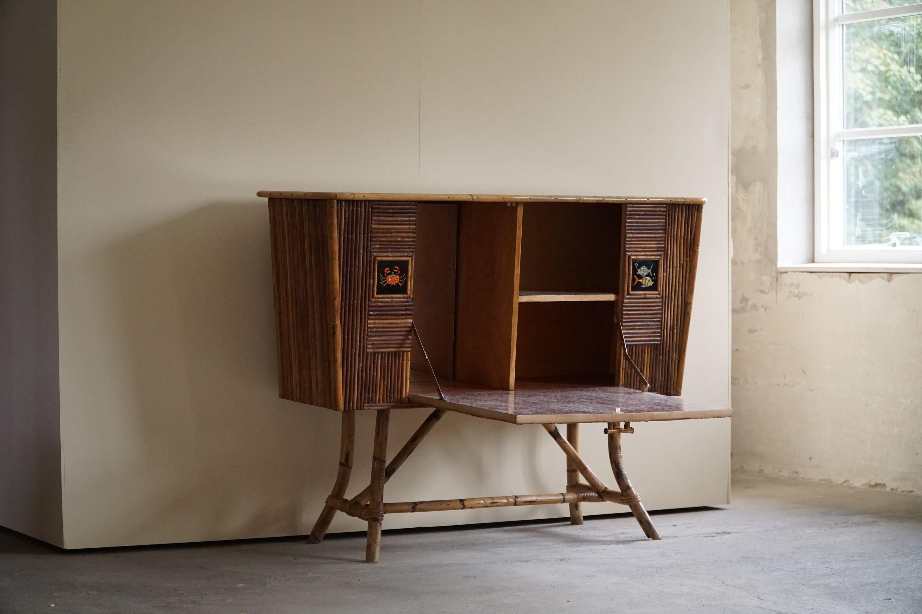 French Modern rattan cabinet / sideboard with figurative ceramic fronts and laminated top. This cabinet is attributed to Adrien Audoux and Frida Minet, made in 1960s.

This beautiful vintage / bohemian piece fits well in the modern interior aswell