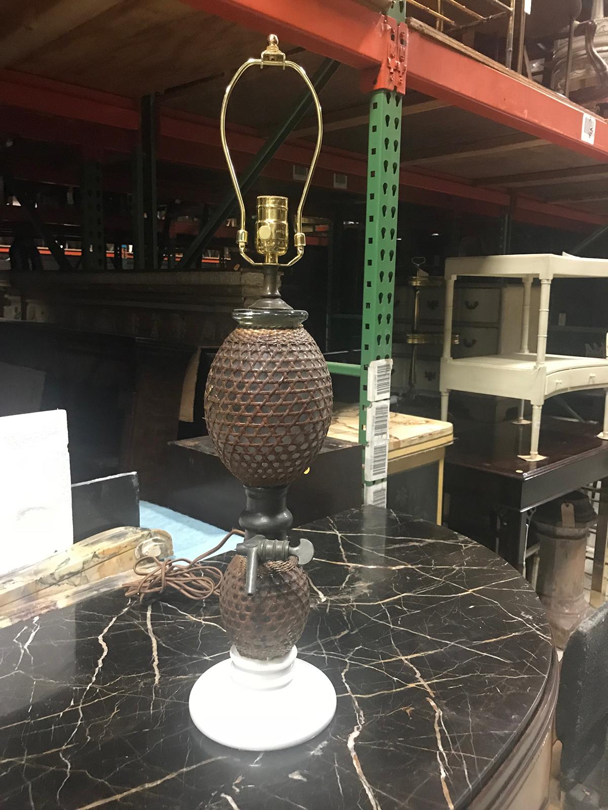 20th century rattan covered glass seltzer bottle as lamp, white ceramic base, pewter spout
New wiring.