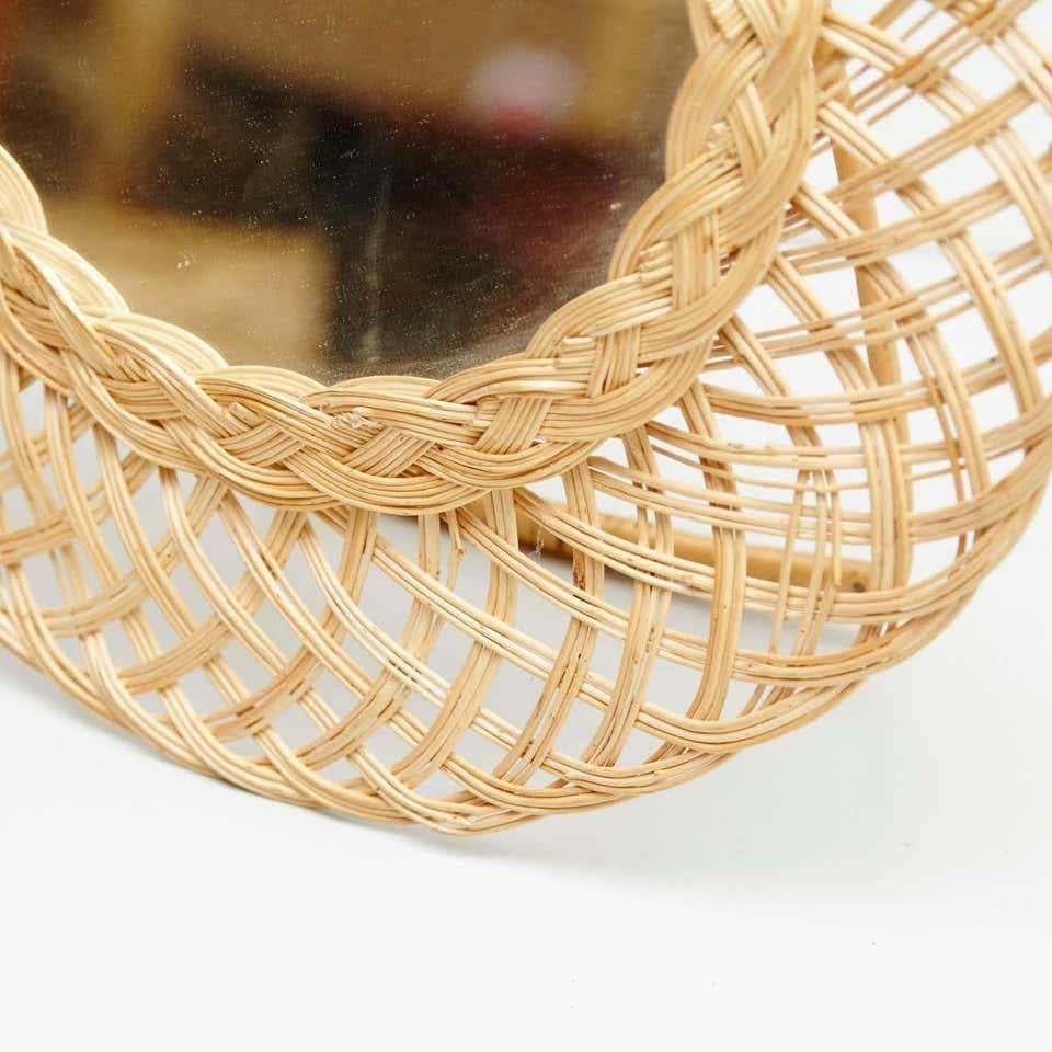 20th Century antique rattan tabletop mirror. By unknown manufacturer, Spain.  In original condition, with minor wear consistent with age and use, preserving a beautiful patina.  Materials: Rattan Mirror  Dimensions: ø 45 cm x D 4 cm.