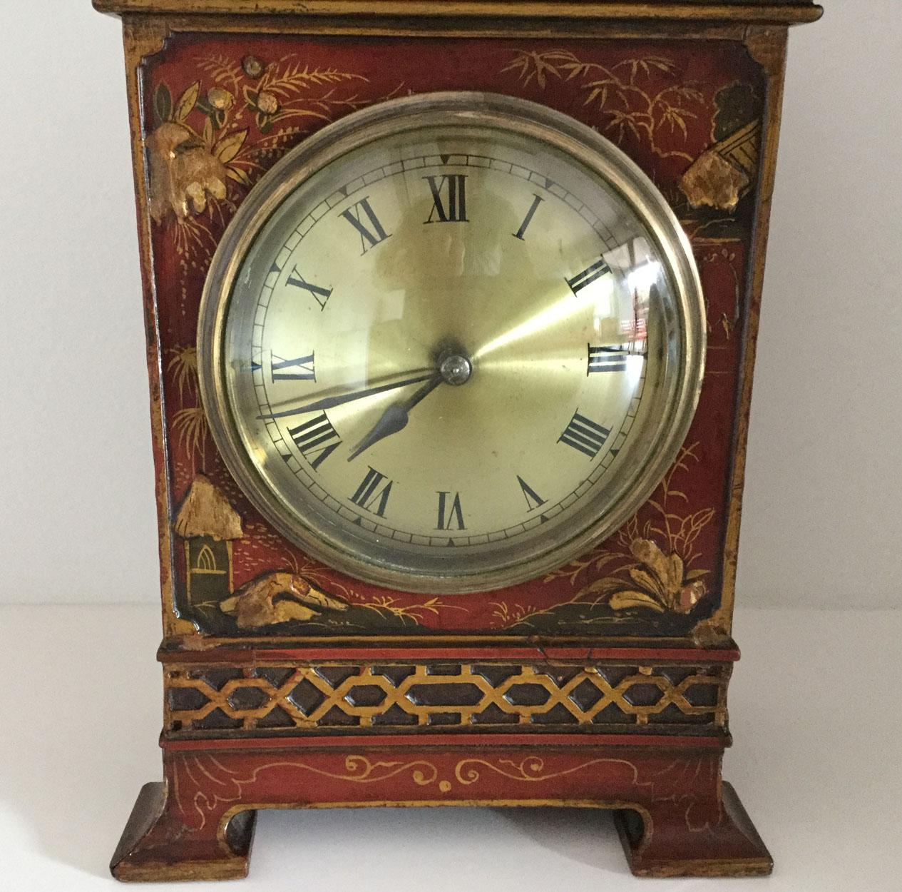 A decorative English red chinoiserie pagoda topped mantel (fireplace) clock circa 1920, the brass dial is in perfect condition. The pagoda top with gilt highlights, the rectangular case with geometric frieze decoration to the base and scenes of a