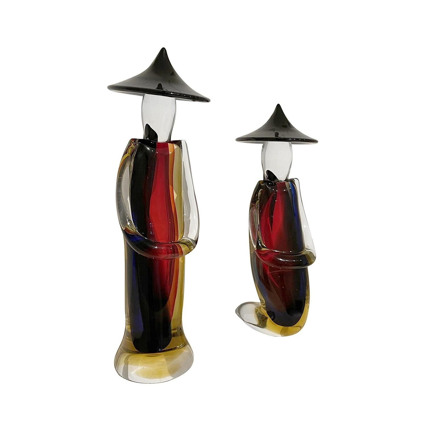 A red, vintage Mid-Century Modern Italian pair of large Japanese farmers with a large black hat made of hand blown colored Murano glass, in good condition. The detailed décor pieces represent a woman and man. Signed at the bottom. Manufacturer label