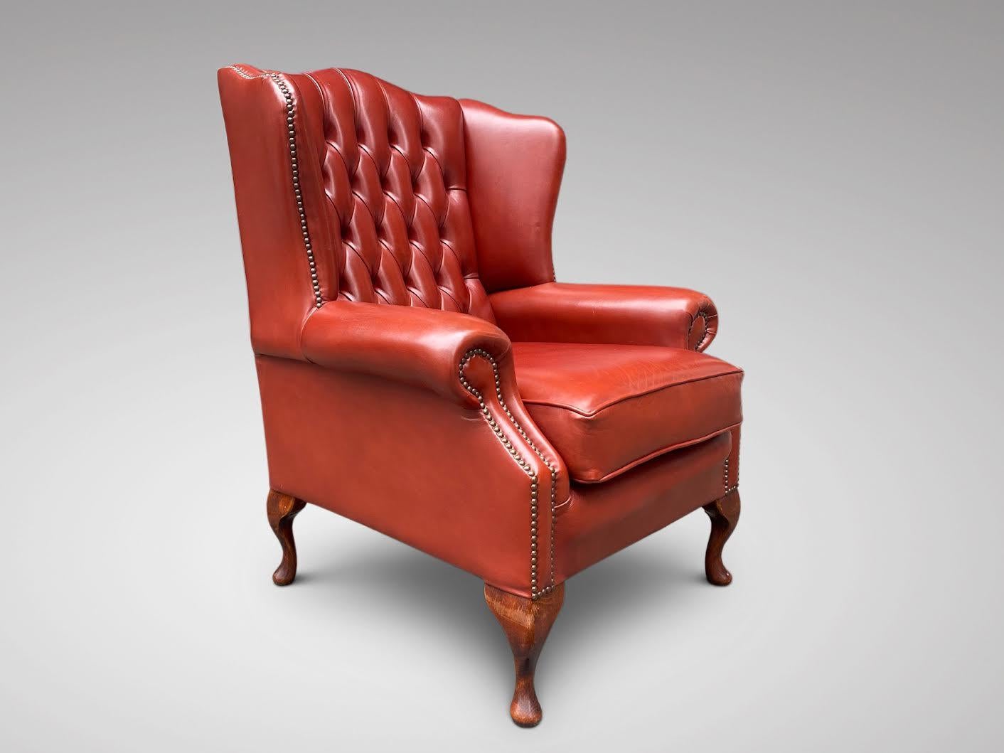 A very comfortable and good quality mid century red leather wing armchair with buttoned back and loose cushion, standing on walnut cabriole feet.

The dimensions are:
Height: 107cm (42.1in)
Width: 82cm (32.3in)
Depth: 75cm (29.5in)

Very comfortable