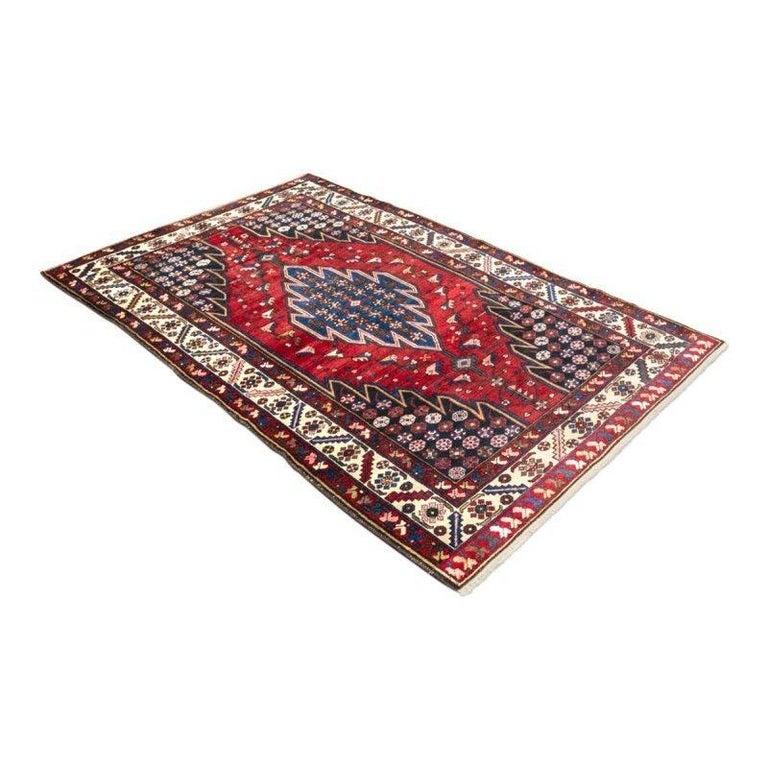Antique Rug Like Shirjan Design in red and blue colors.
- Elaborated in wool with geometric designs throughout the central field.
- Its borders in beige and red background alternate floral patterns and geometries in different colors.
- Great