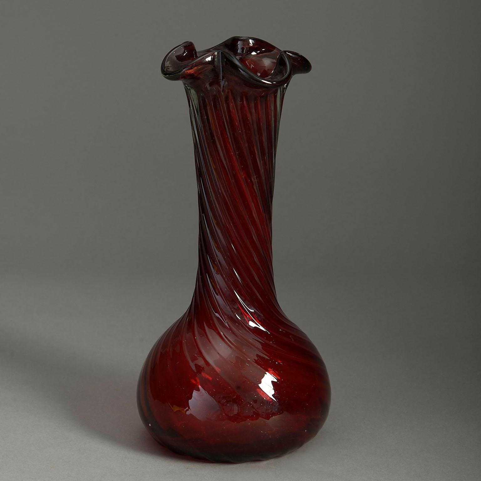 An early 20th century red swirl glass vase, the shaped rim upon a tall stem with bulb base.