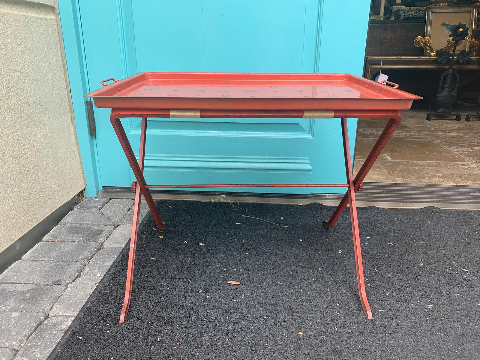 Charming 20th century red tole tray on stand with star detail.