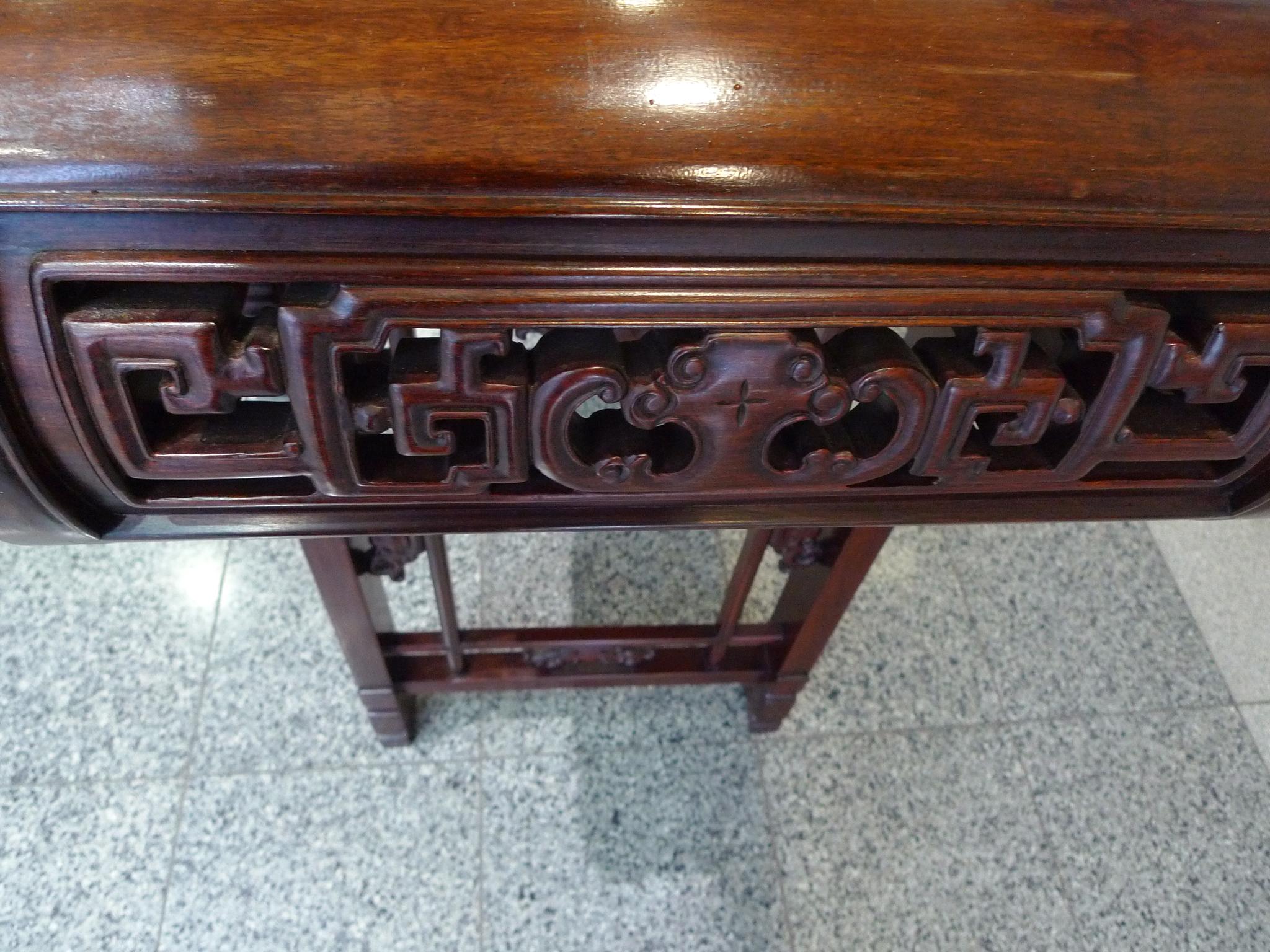 This vintage Asian altar table is crafted from Elmwood that has been newly refinished, restoring the wood's rich, warm red-brown color. The table's clean, straight lines round into soft edges. The overall design consists of beautifully and