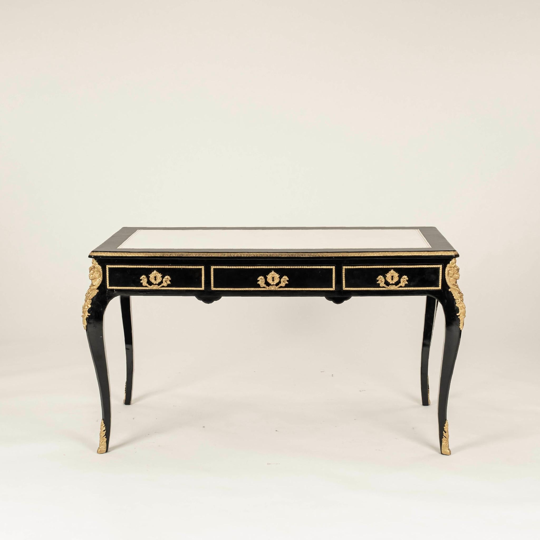 20th Century Regency style black lacquered desk featuring brass ormolu and hardware with gilt embossed white leather top.