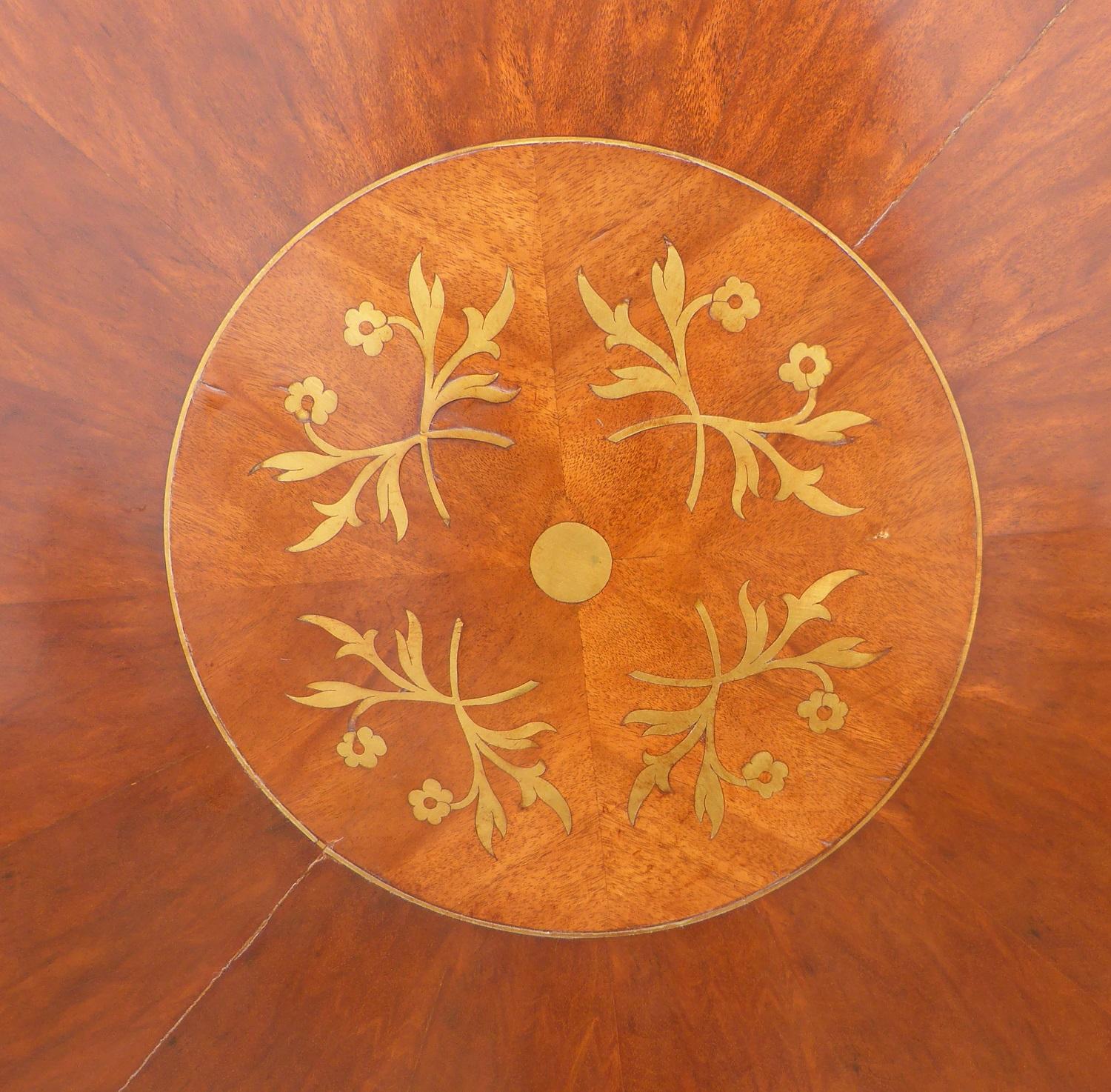 For sale is a good quality Regency style mahogany and brass inlaid circular dining table, to seat 8 people. The top of the table has nice brass inlay to the edge, as well as to the centre. The top screws onto the base, which stands on three carved