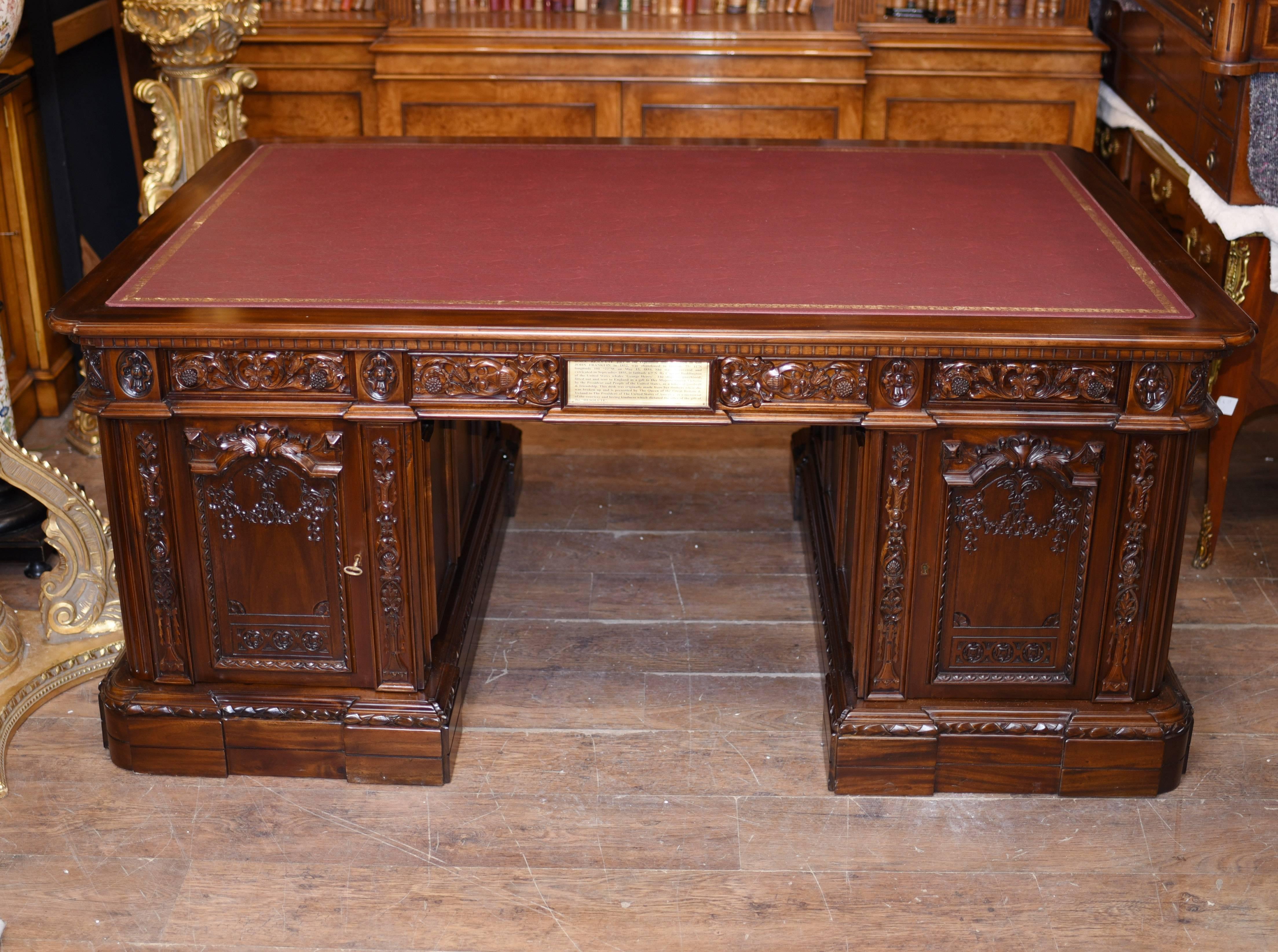 A 20th century replica of the white house presidents desk. The original to be found in the Oval office. This desk is made from the best quality mahogany and is profusely carved with various forms, including the large eagle with the shield, snake,